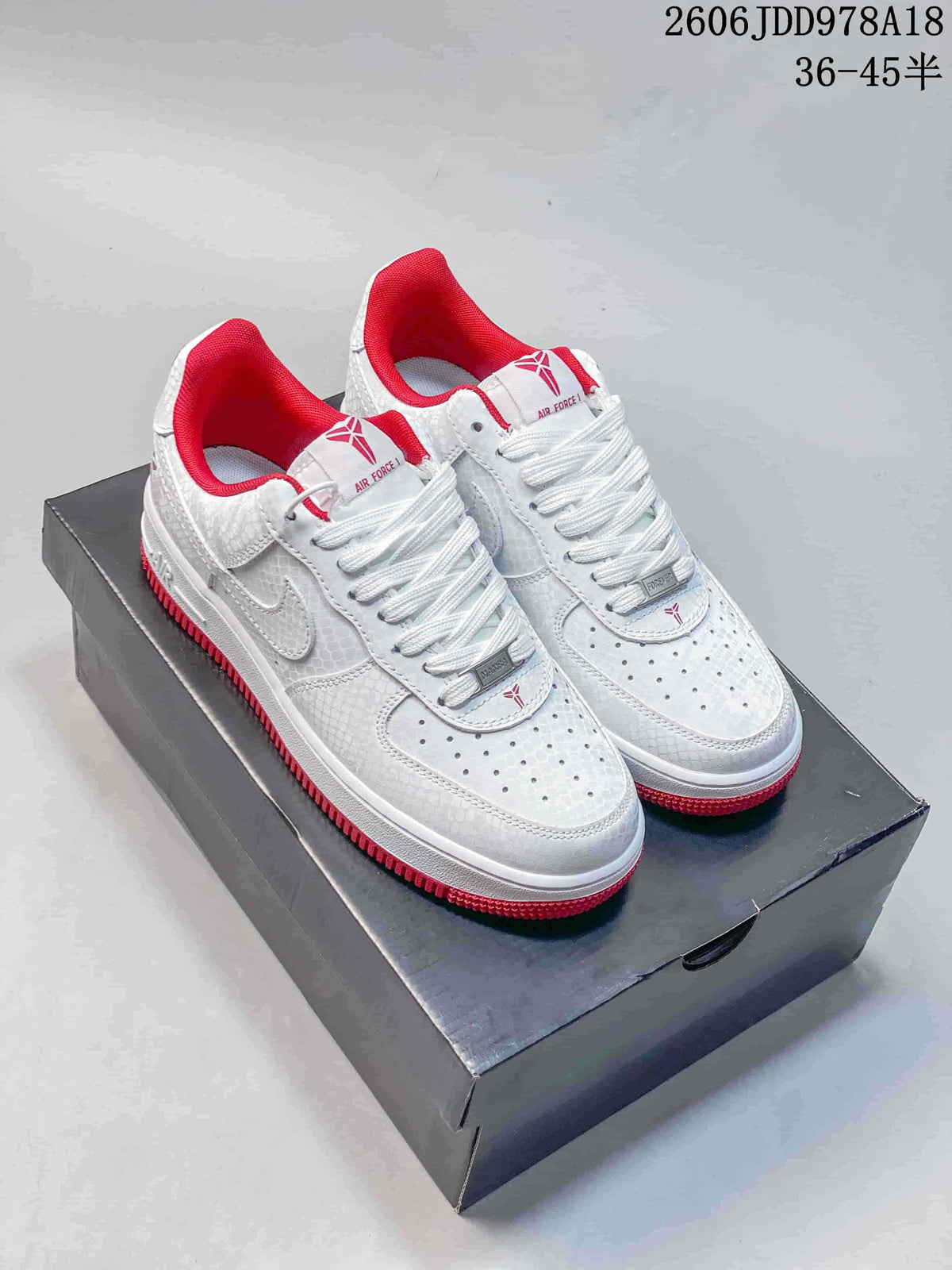 White patterned low-top sneakers with red lining and red outsoles, shown on a shoebox