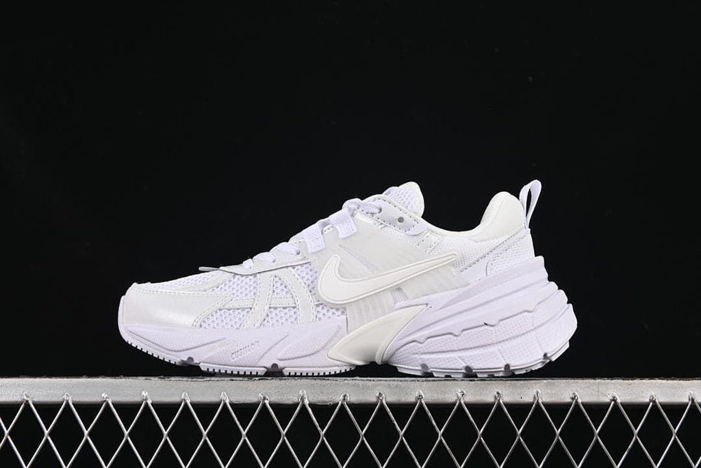 Side view of a white Nike V2K Run sneaker against a dark background