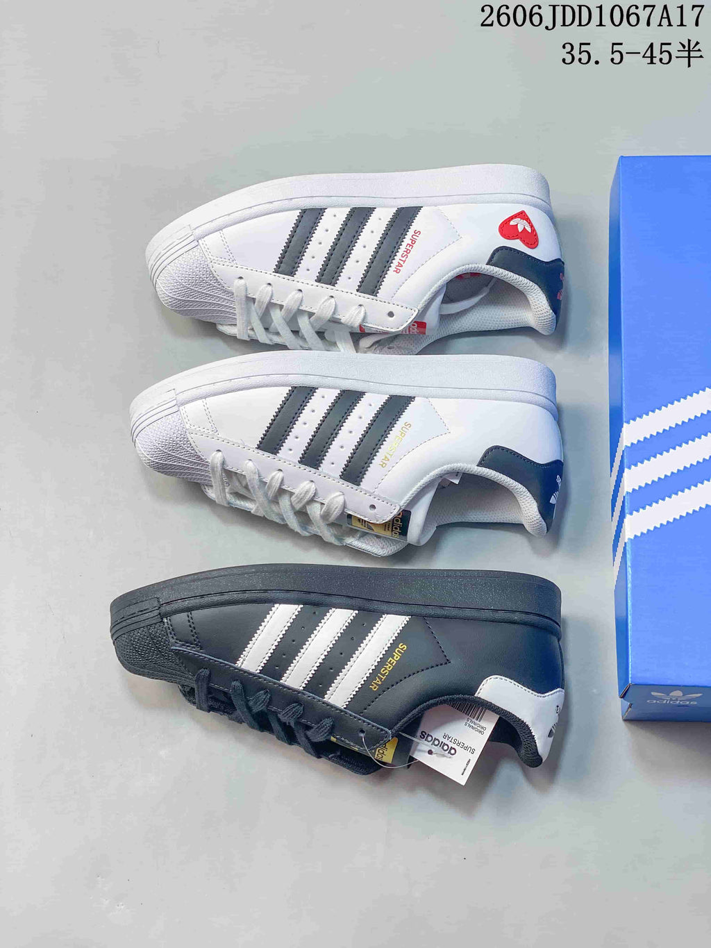 White and dark gray Adidas Superstar sneakers shown from the side.