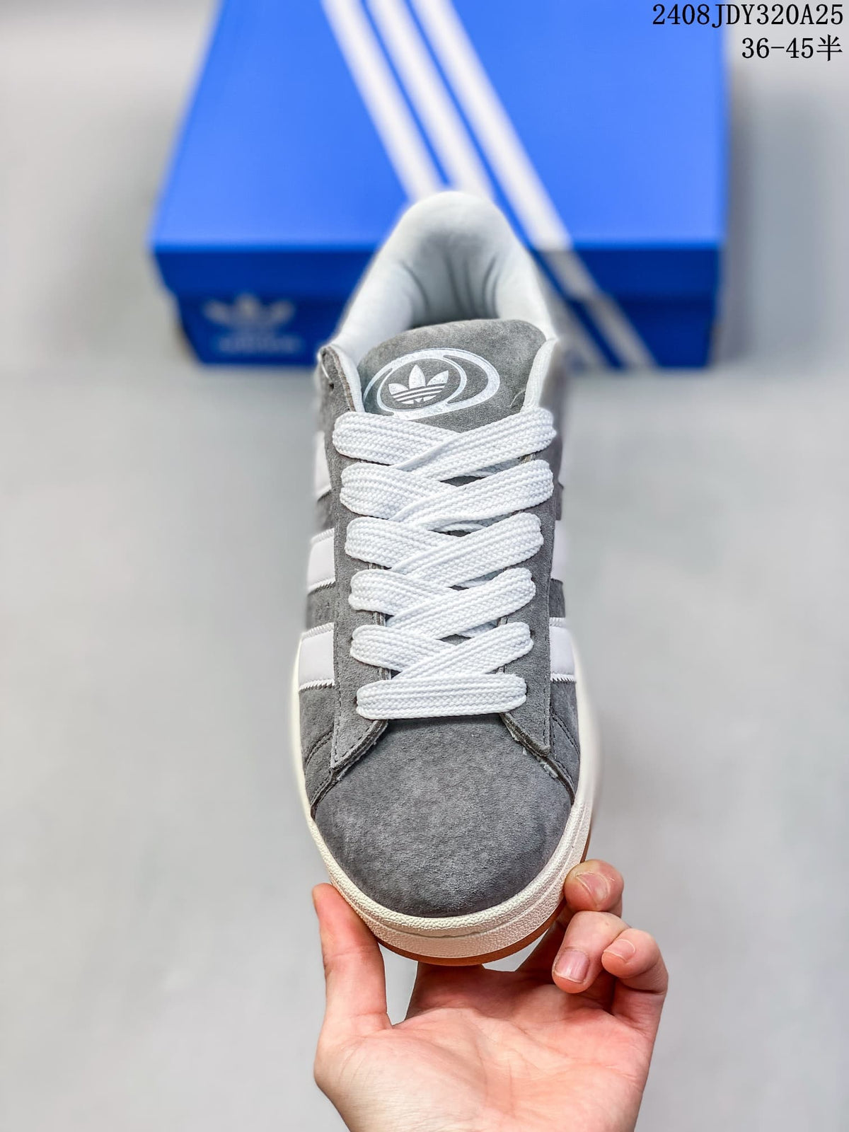 Front view of the grey sneaker with white laces and trefoil tongue branding.