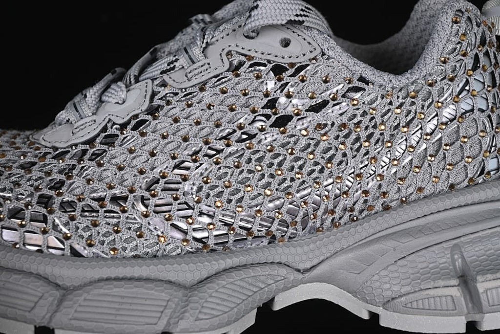 Close-up of the sneaker's openwork upper, reflective-looking accents, and gold-tone details.