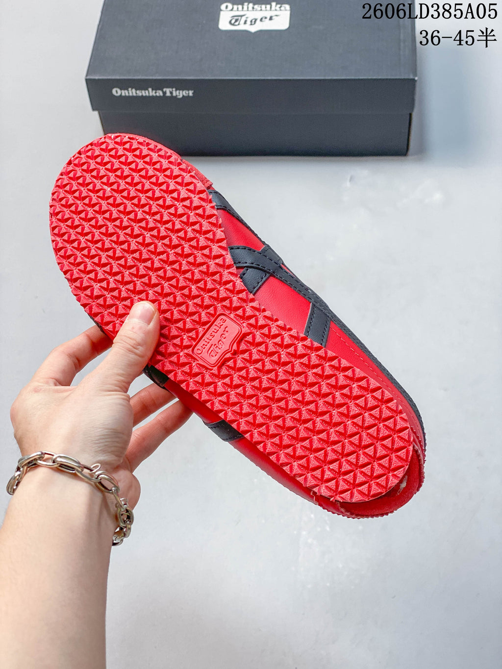 Textured red outsole of the sneakers beside the branded shoebox