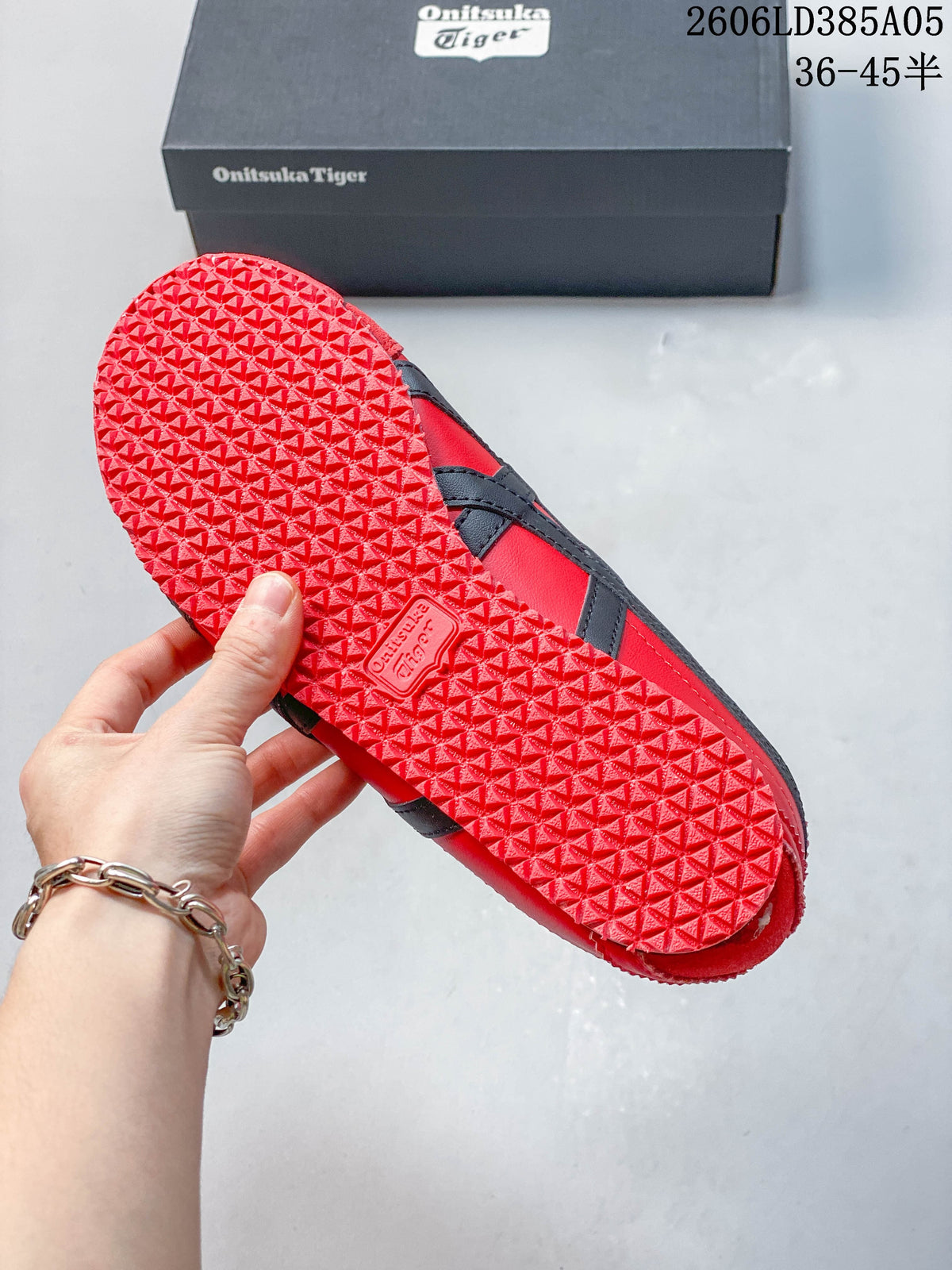 Textured red outsole of the sneakers beside the branded shoebox