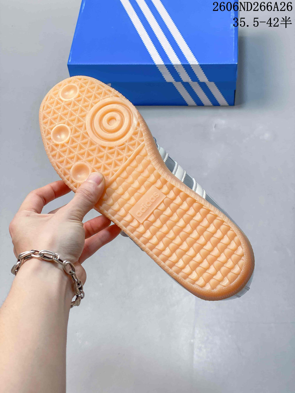 Underside view of the gum-colored outsole with patterned tread on a silver Samba Jane sneaker.