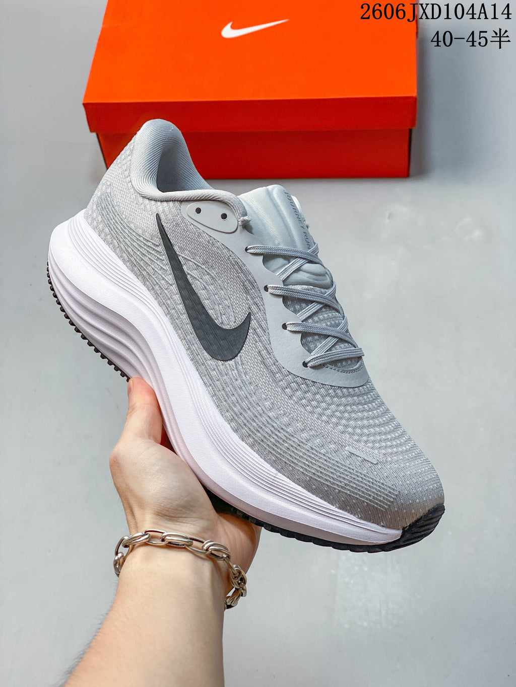 Close-up side view of a light gray Nike Journey Run running shoe with a dark Swoosh and thick white midsole.