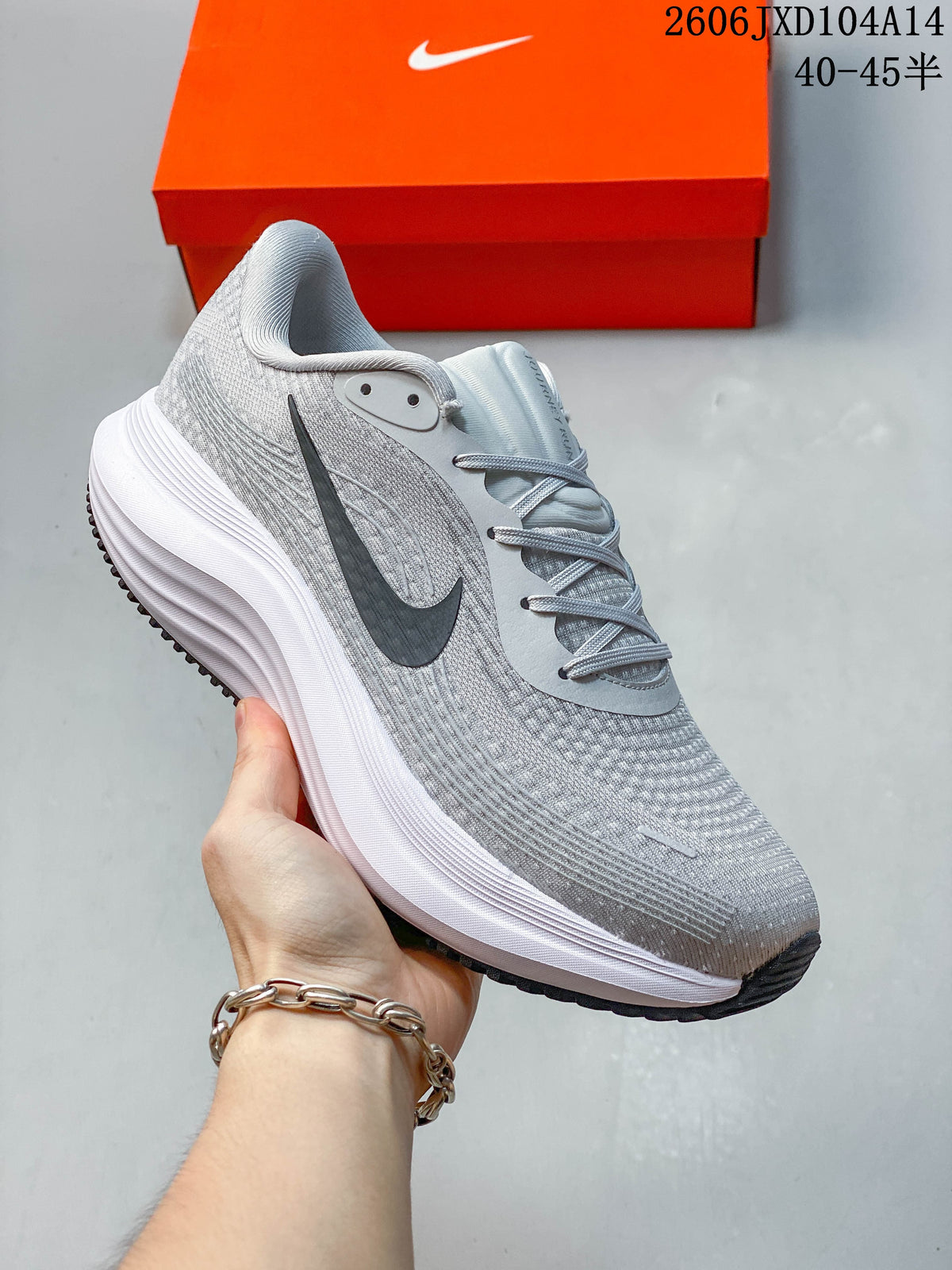 Close-up side view of a light gray Nike Journey Run running shoe with a dark Swoosh and thick white midsole.