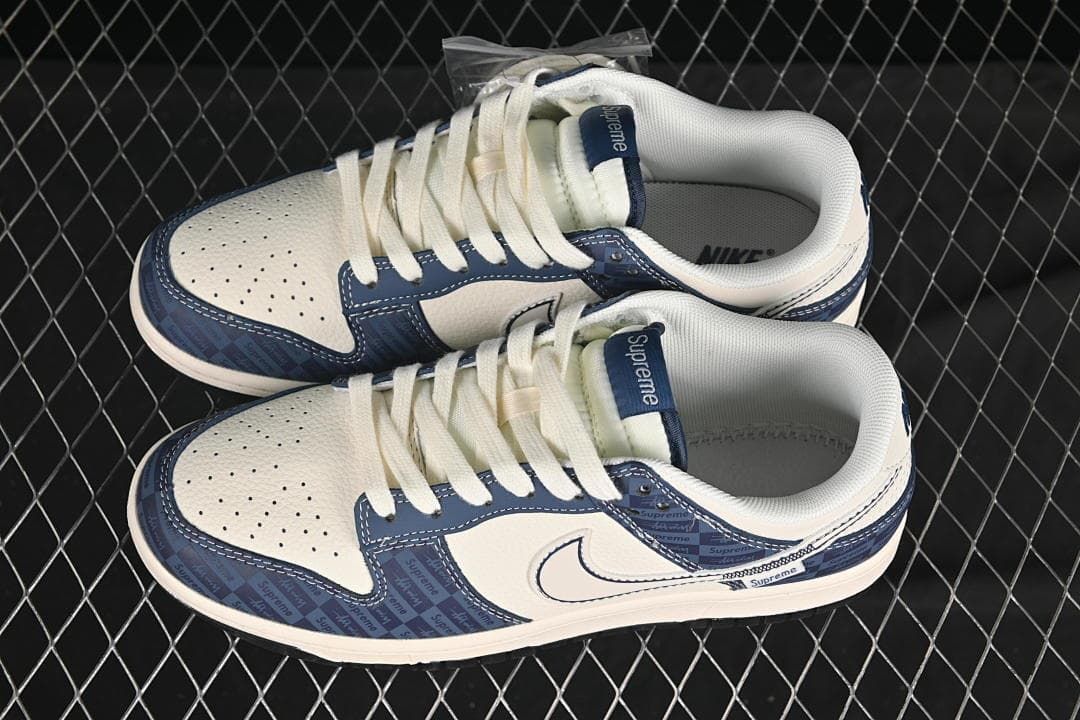 Pair of cream and navy low-top sneakers with white laces and patterned overlays, photographed from above.