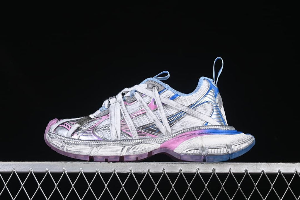 Side view of a white and silver-toned Balenciaga 3XL sneaker with pink and blue accents
