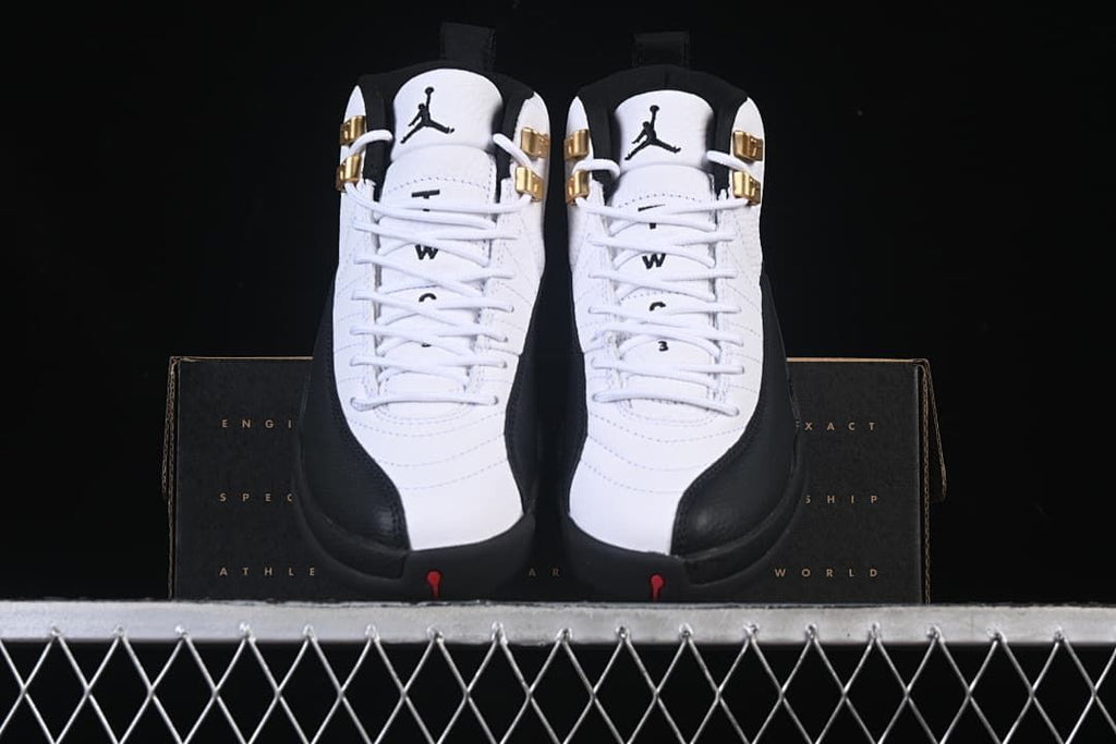 Front view of the pair showing white uppers, black trim and gold-tone lace hardware.