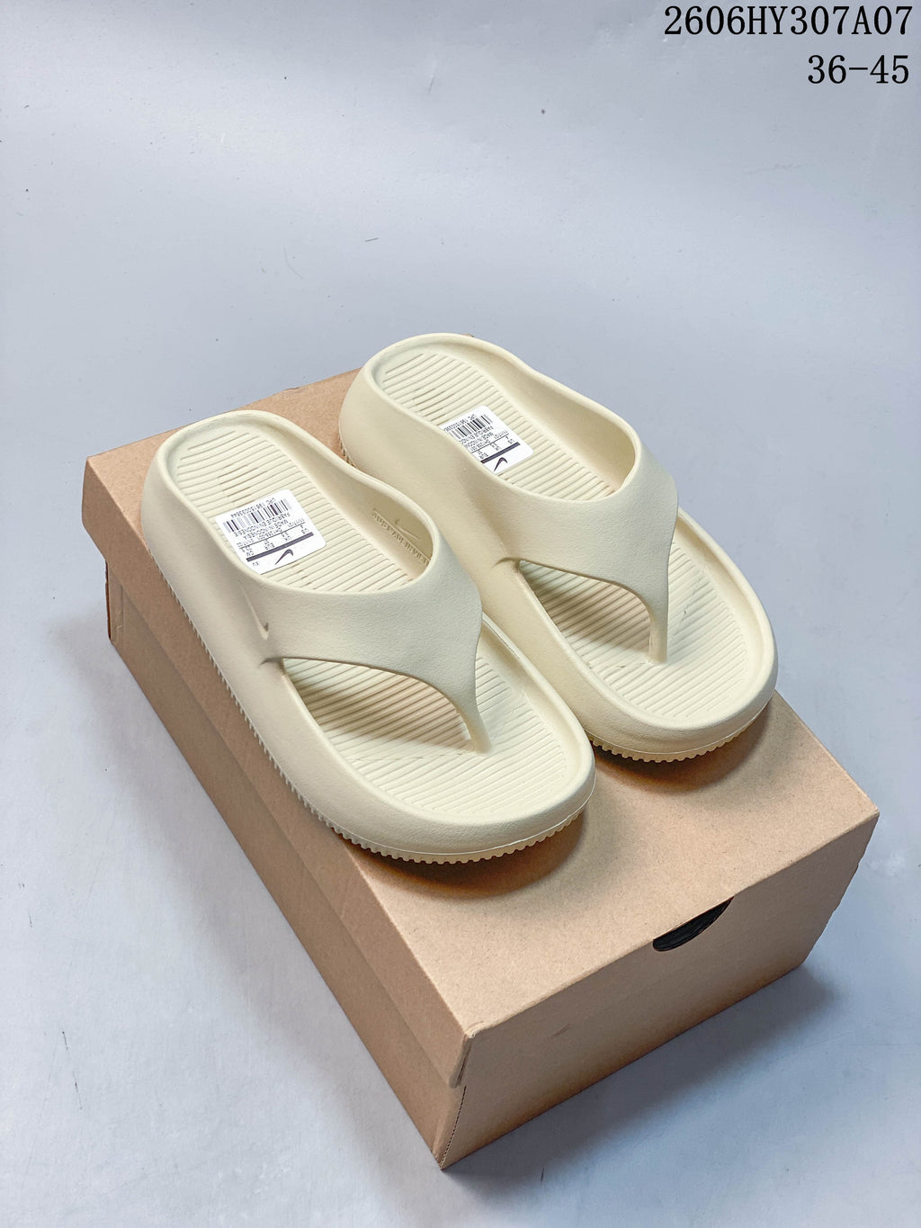Pair of pale cream Nike Calm Slide thong sandals shown from above