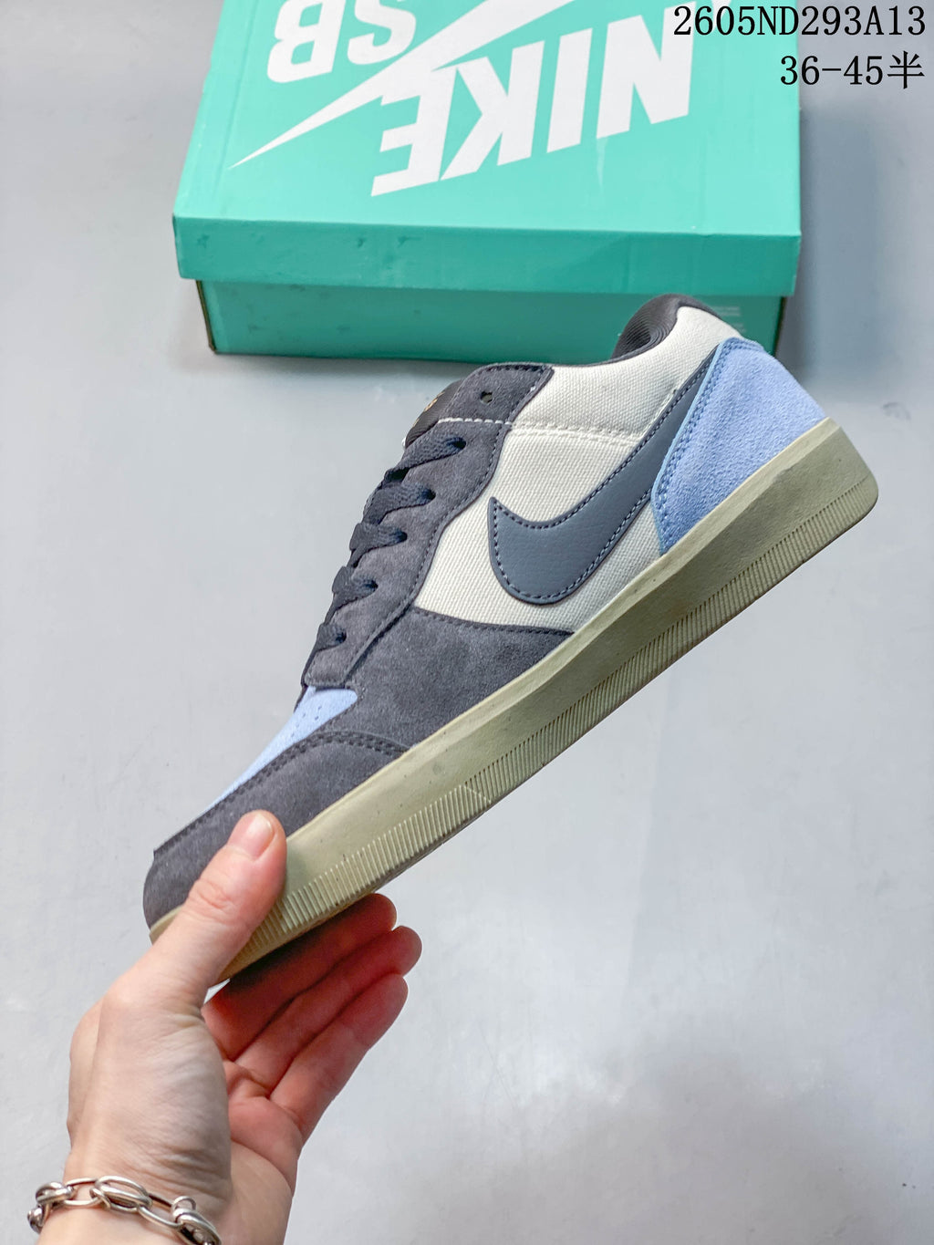 Side view of the shoe with gray, cream, and light blue panels.