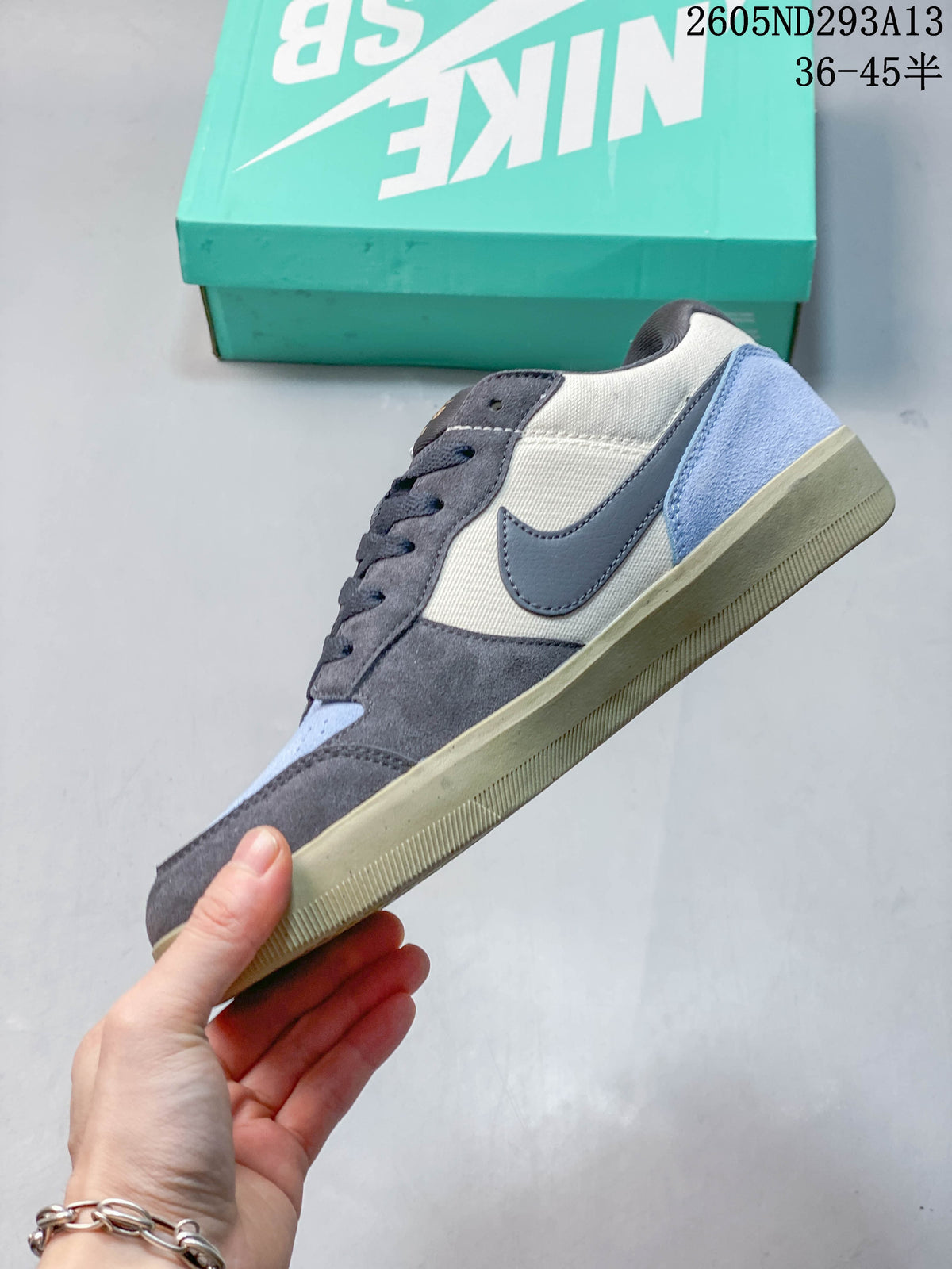 Side view of the shoe with gray, cream, and light blue panels.