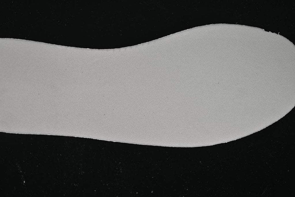 Light-colored shoe insert shown against a dark background