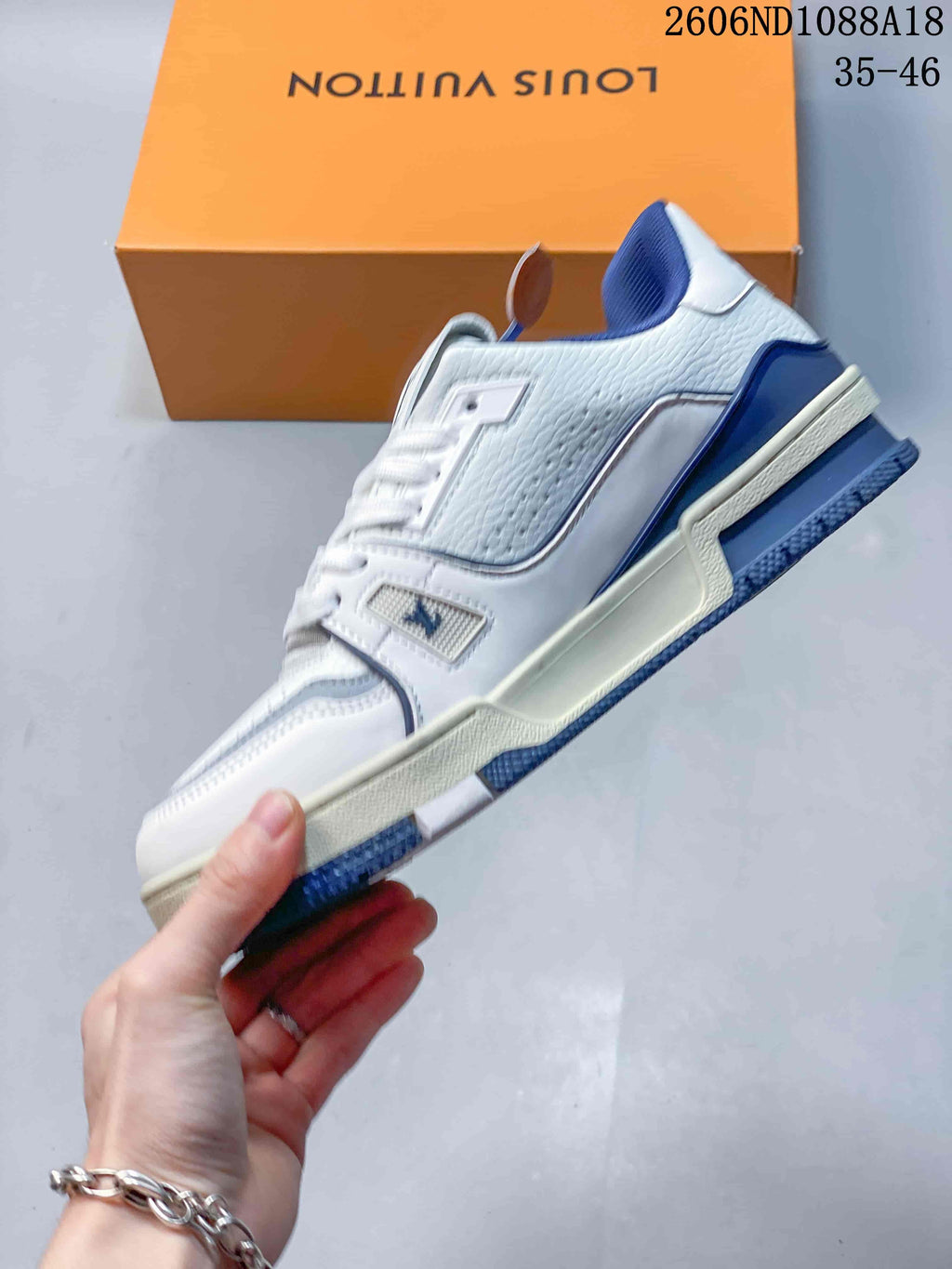 Side profile of a white low-top sneaker with blue and gray detailing