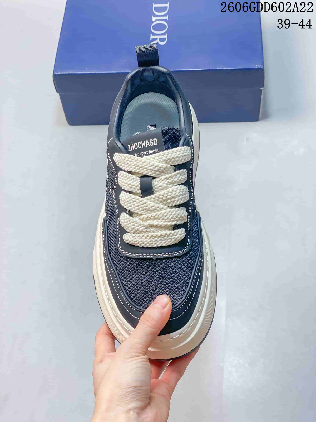Top view of a navy sneaker with textured panels and thick white laces
