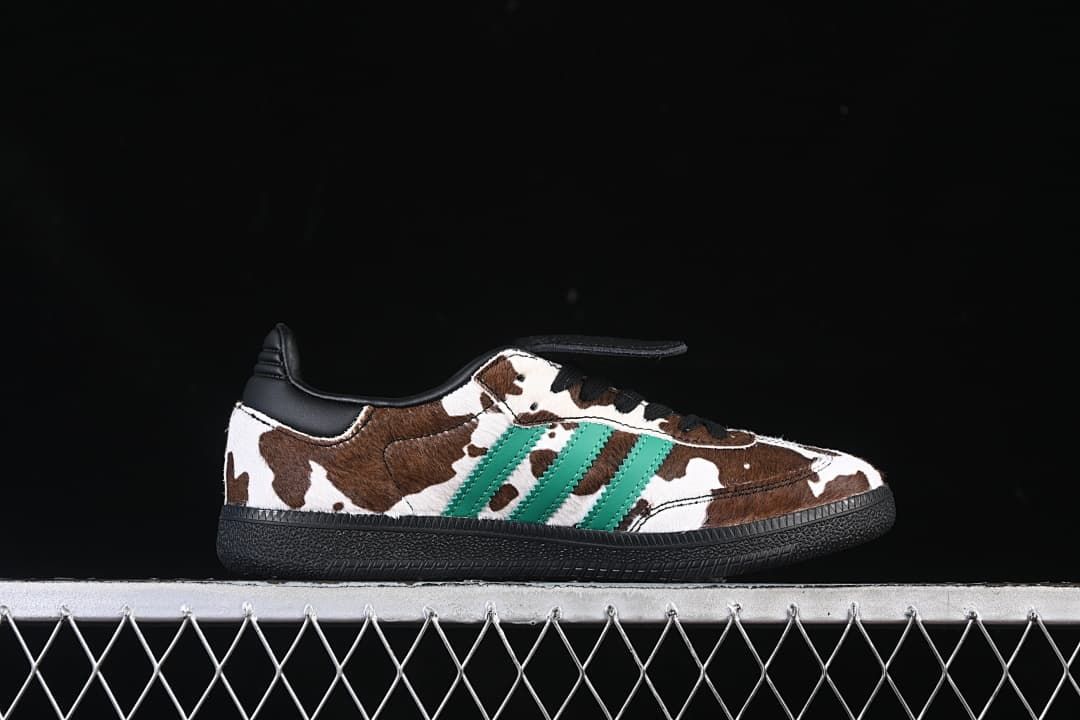 Side profile of one shoe showing the cow-print upper, green stripes and black sole