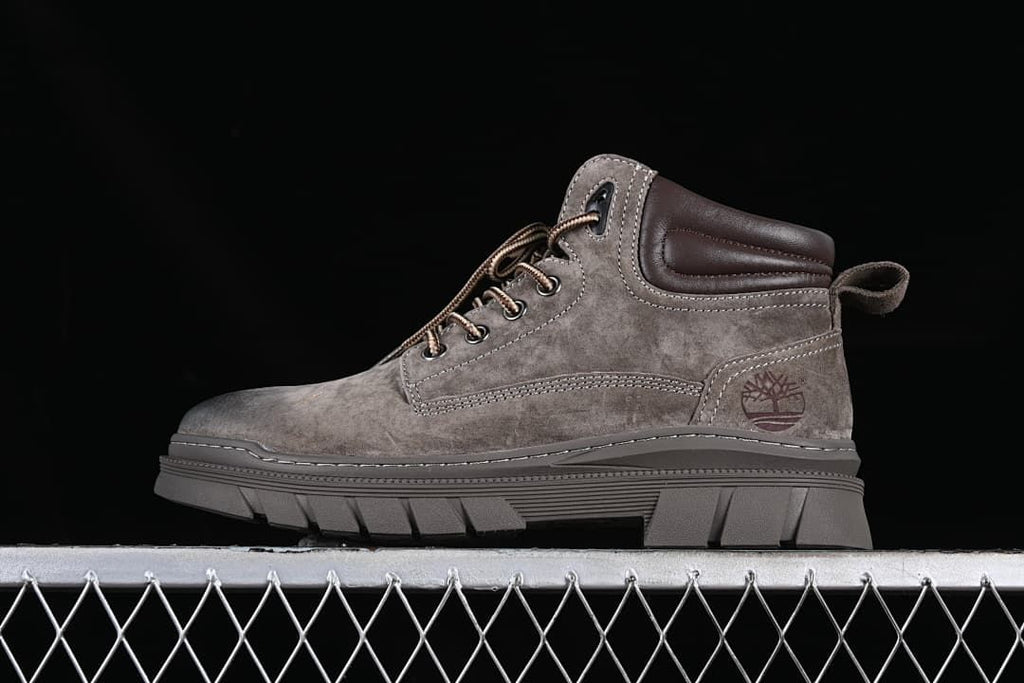 Side view of a brown Timberland-branded mid-top lace-up boot