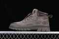 Side view of a brown Timberland-branded mid-top lace-up boot