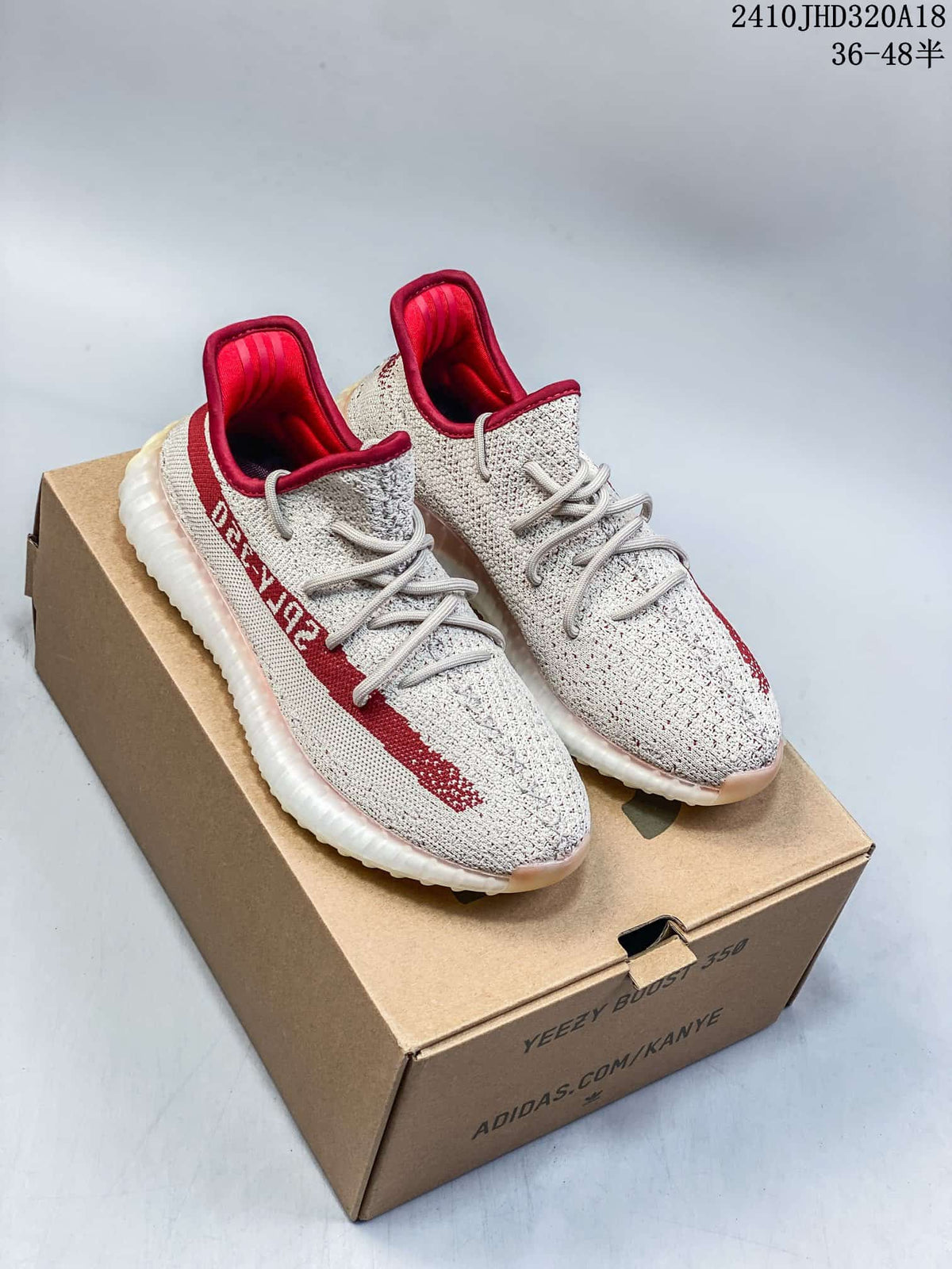 Pair of cream and red Adidas Yeezy Boost 350 V2 sneakers on a box