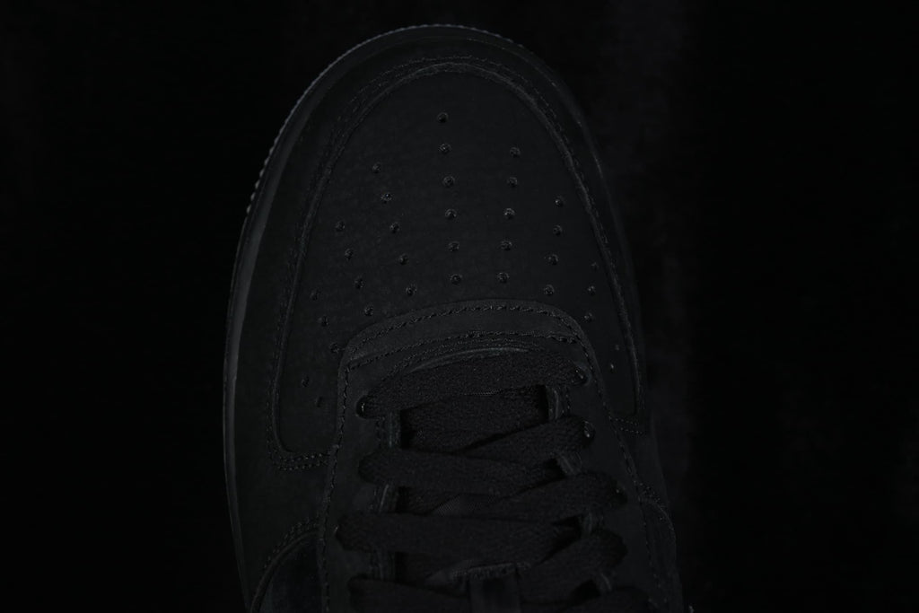 Top-down close-up of the perforated black toe box and black laces.