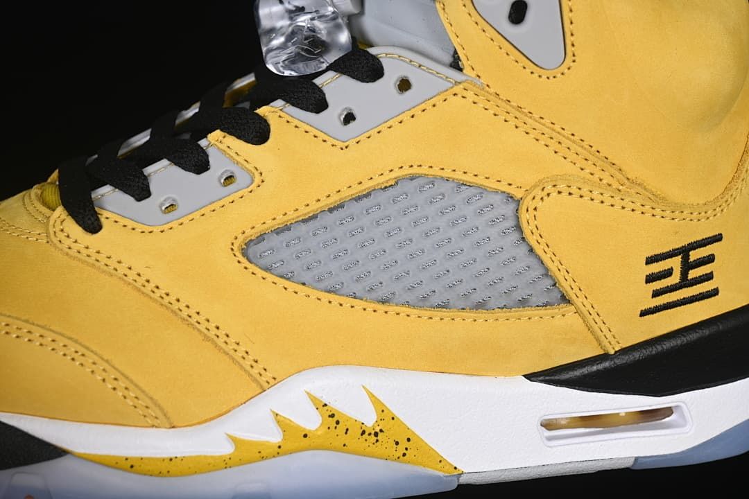 Close-up of the grey side panel, yellow upper, laces, and midsole air unit