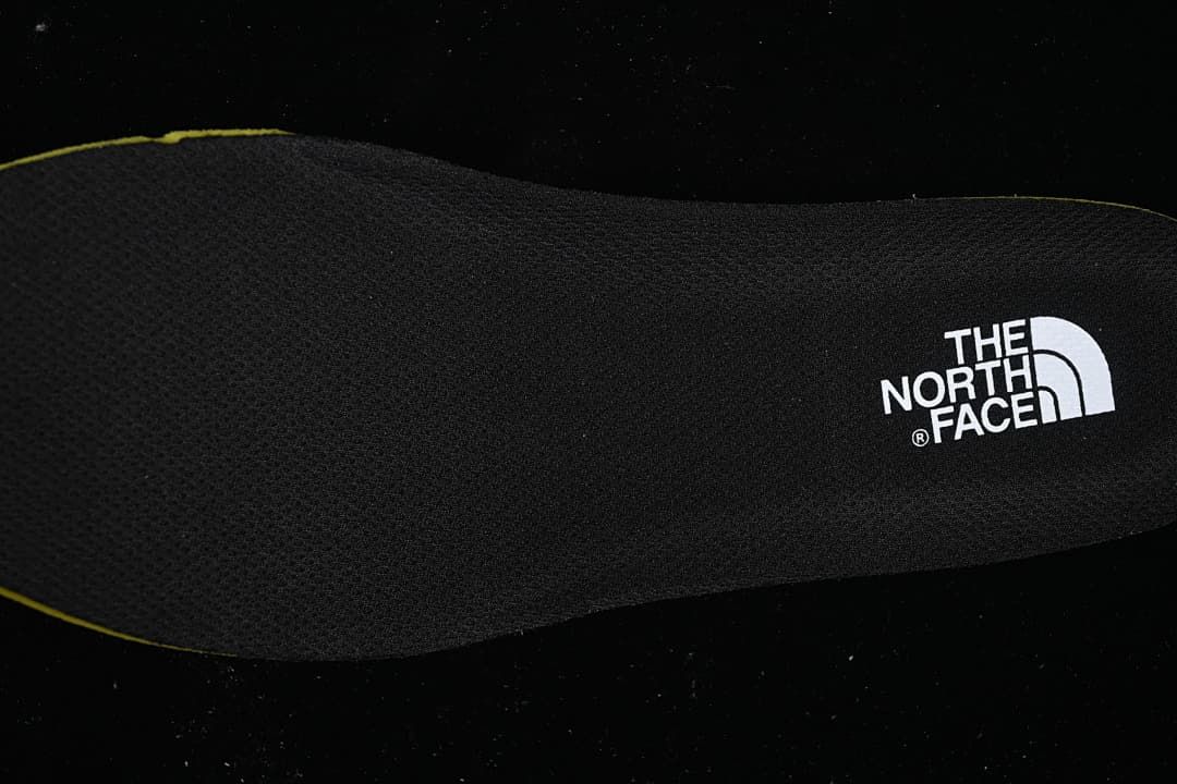 Black insole with The North Face logo and a yellow edge