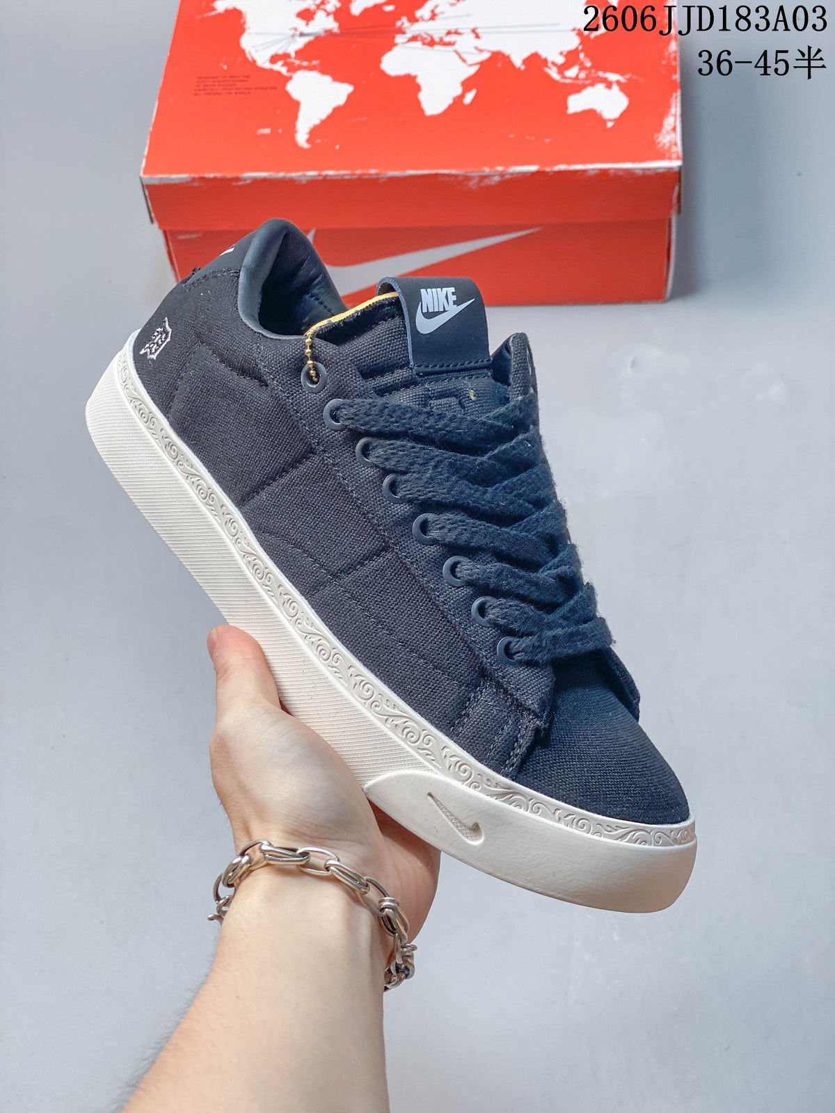 Angled side view of a navy sneaker with BOOK-themed details and a white patterned sole