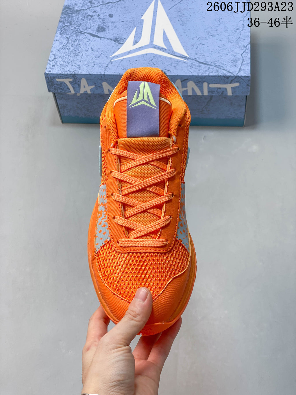 Top view of the orange shoe showing its laces and mesh toe area.