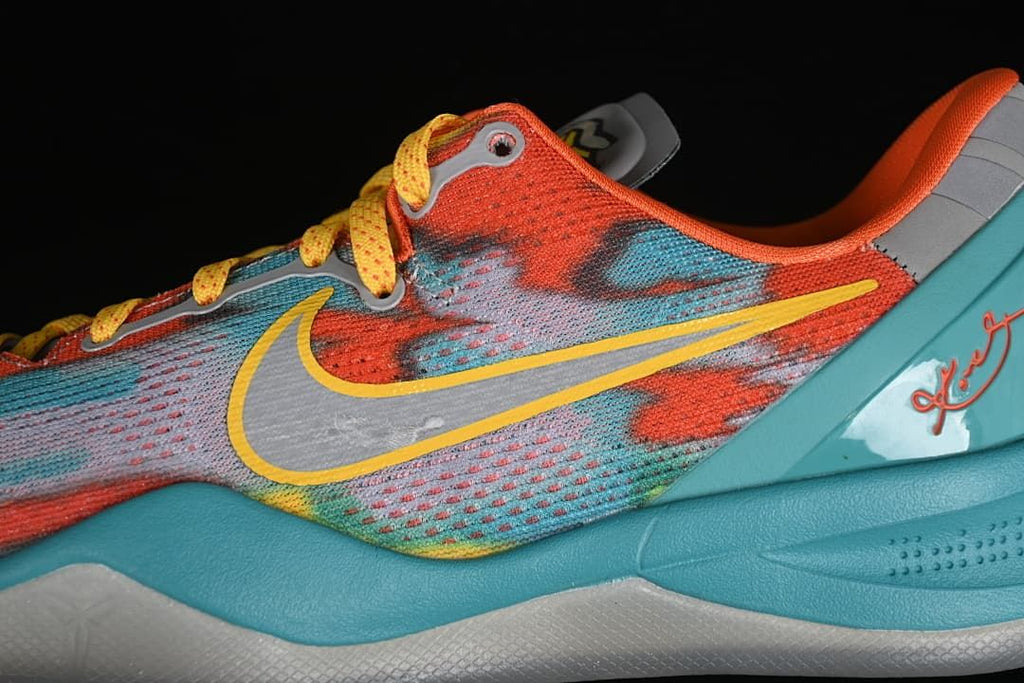 Close-up of the patterned upper, yellow swoosh, and turquoise midsole