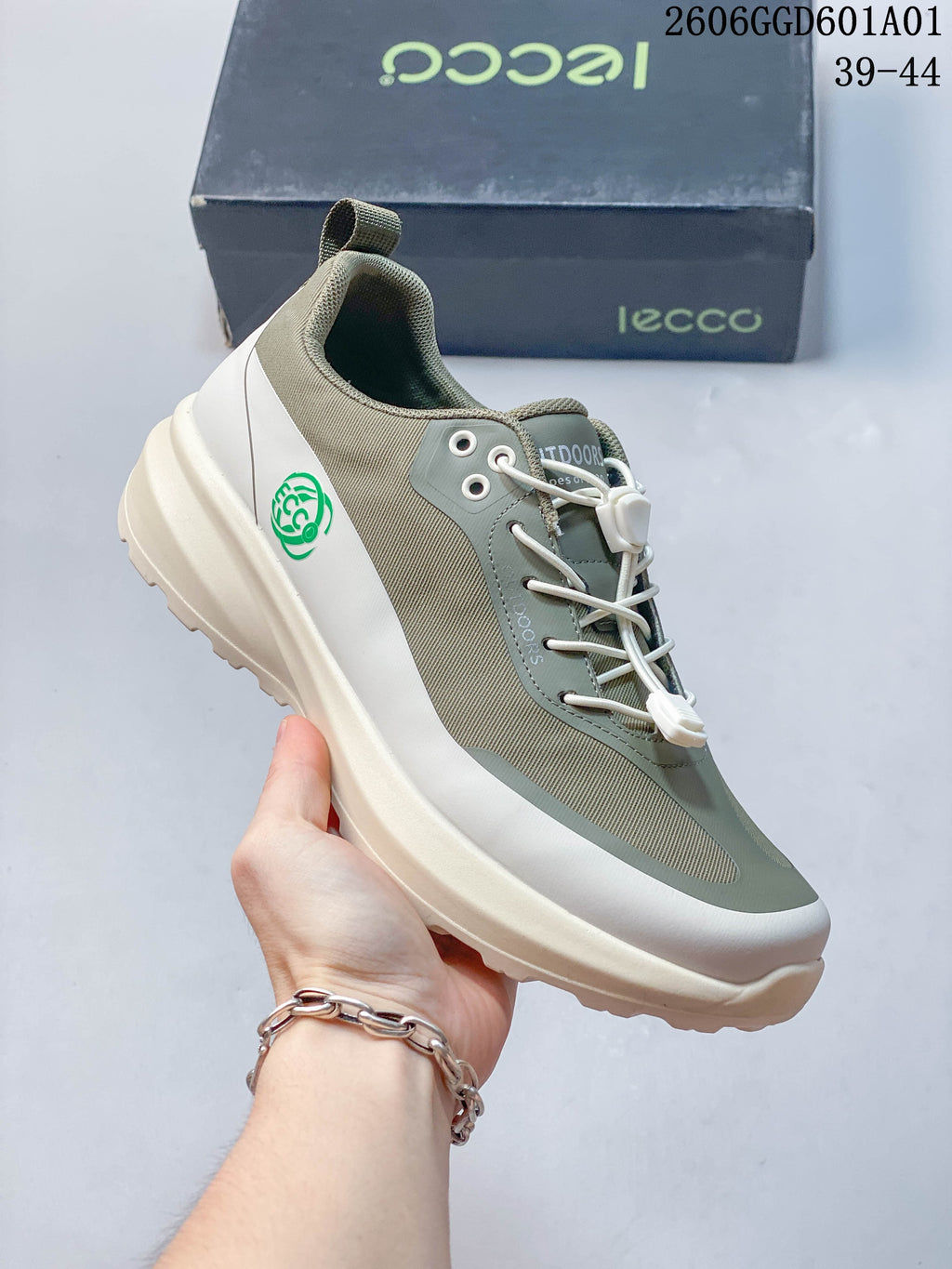 Angled view of a sage and cream lace-up sneaker with a green heel emblem; image overlay lists sizes 39–44.