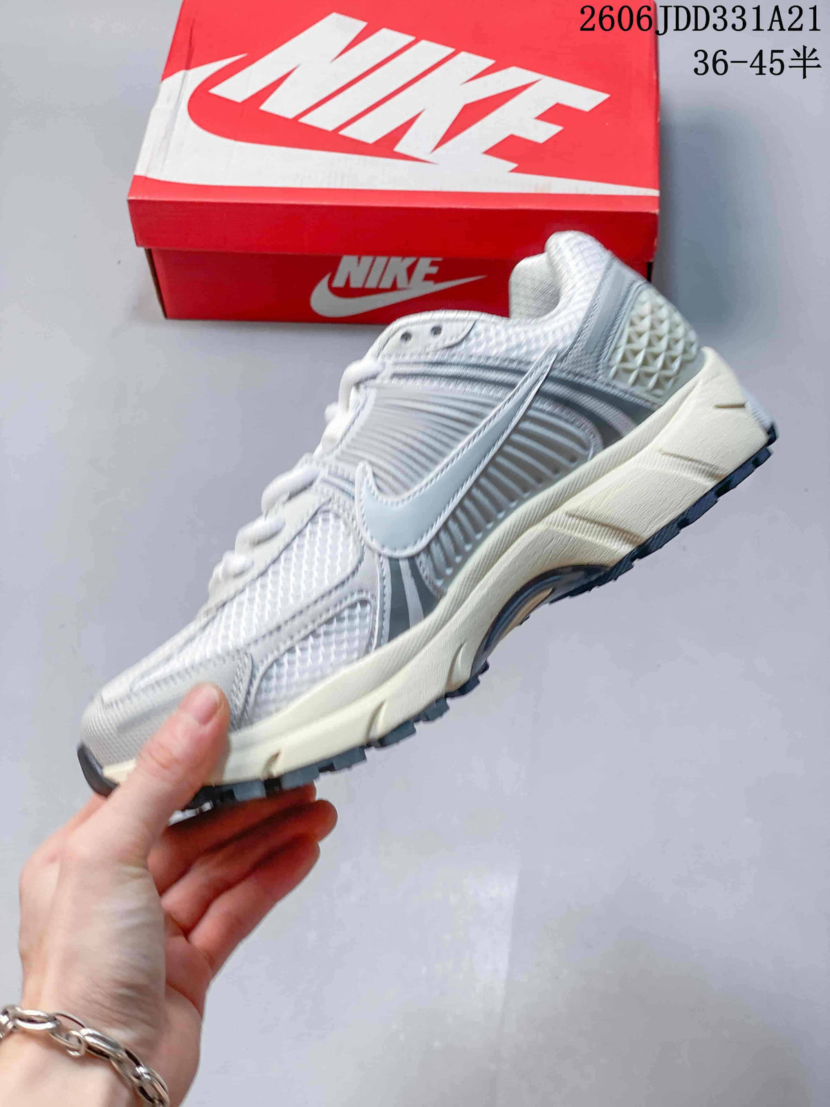 Side profile of a white and grey Nike Zoom Vomero 5 sneaker