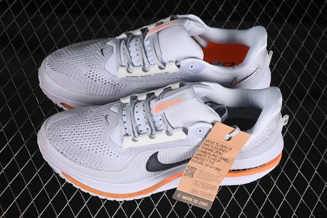 Pair of light gray and white shoes with orange accents