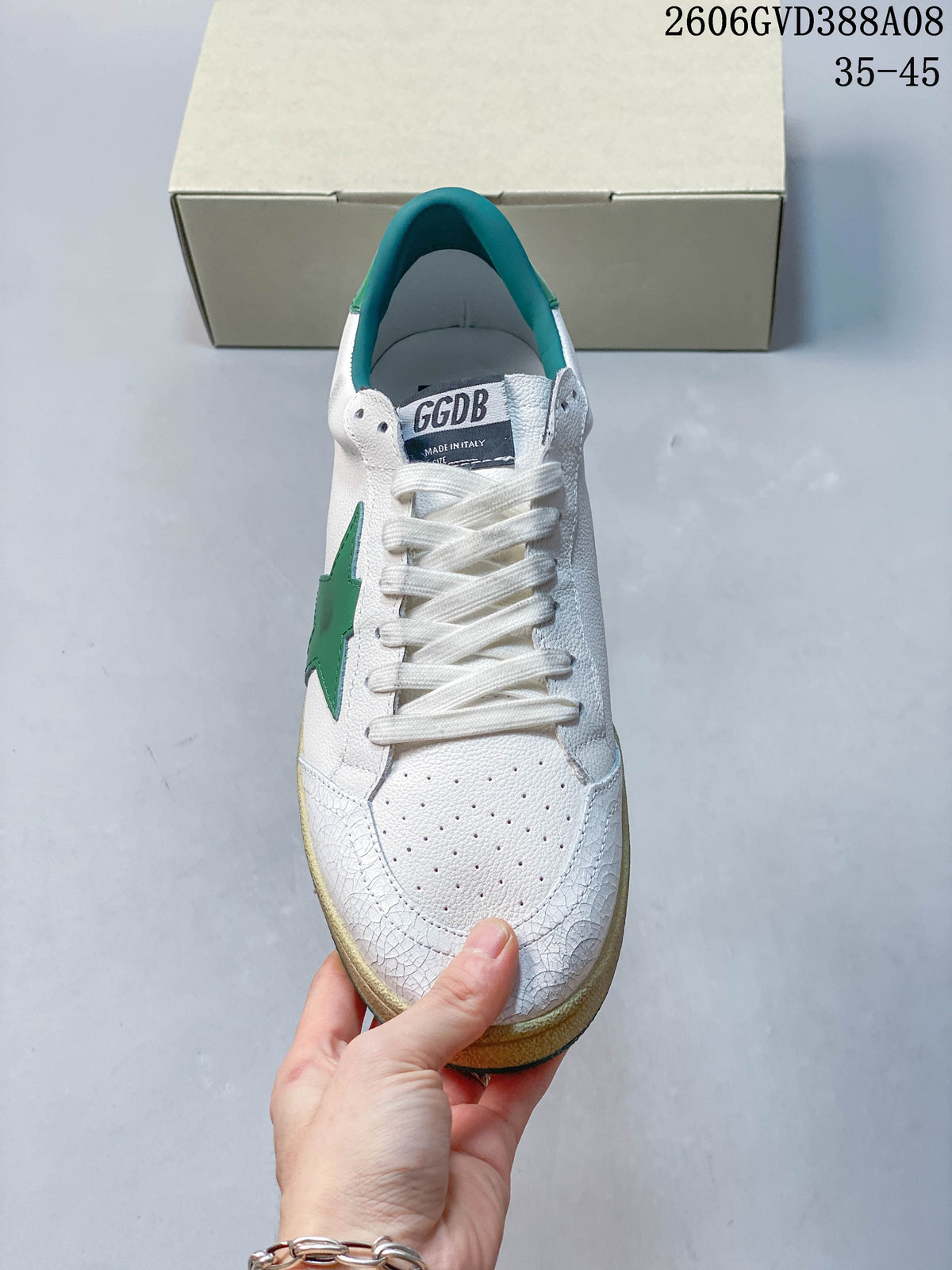 Front view showing white laces, perforated toe and green star detail