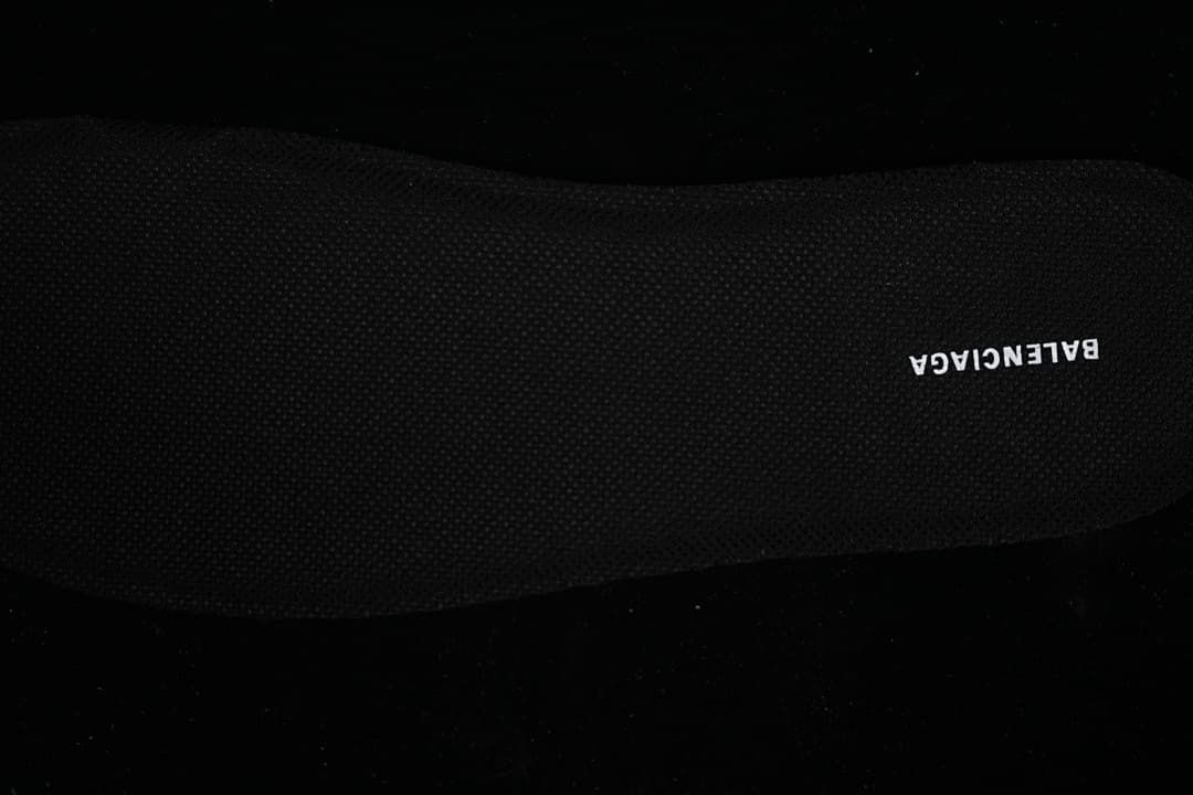 Close-up of the black insole with white branding.