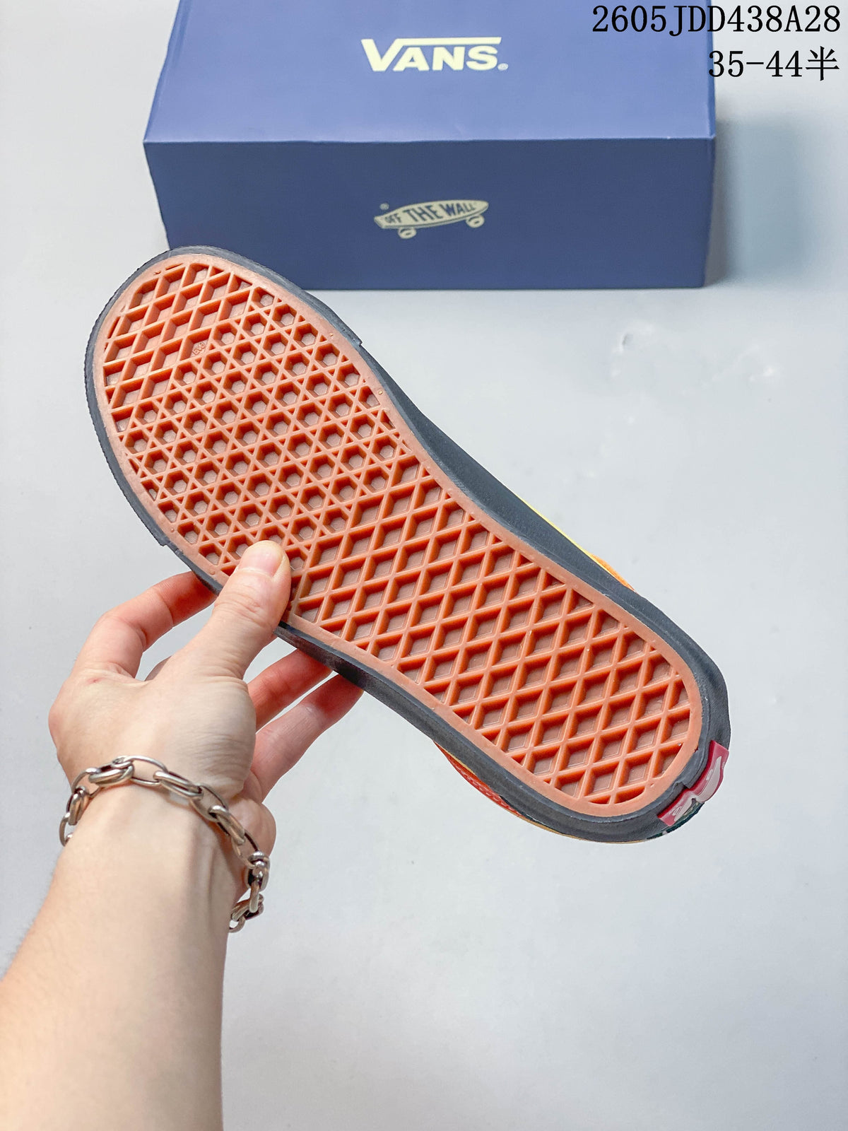 Close-up of the sneaker outsole with a patterned tread and Vans shoebox in the background