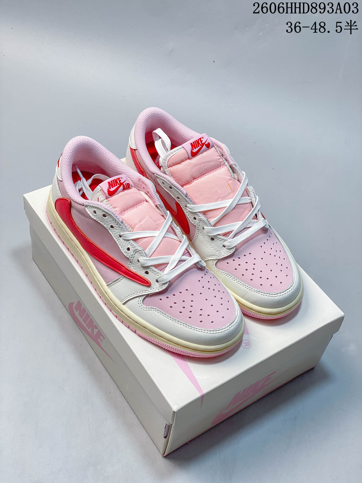 Pair of pink, white, and red low-top Air Jordan 1 sneakers on a branded box; image overlay states a size range.