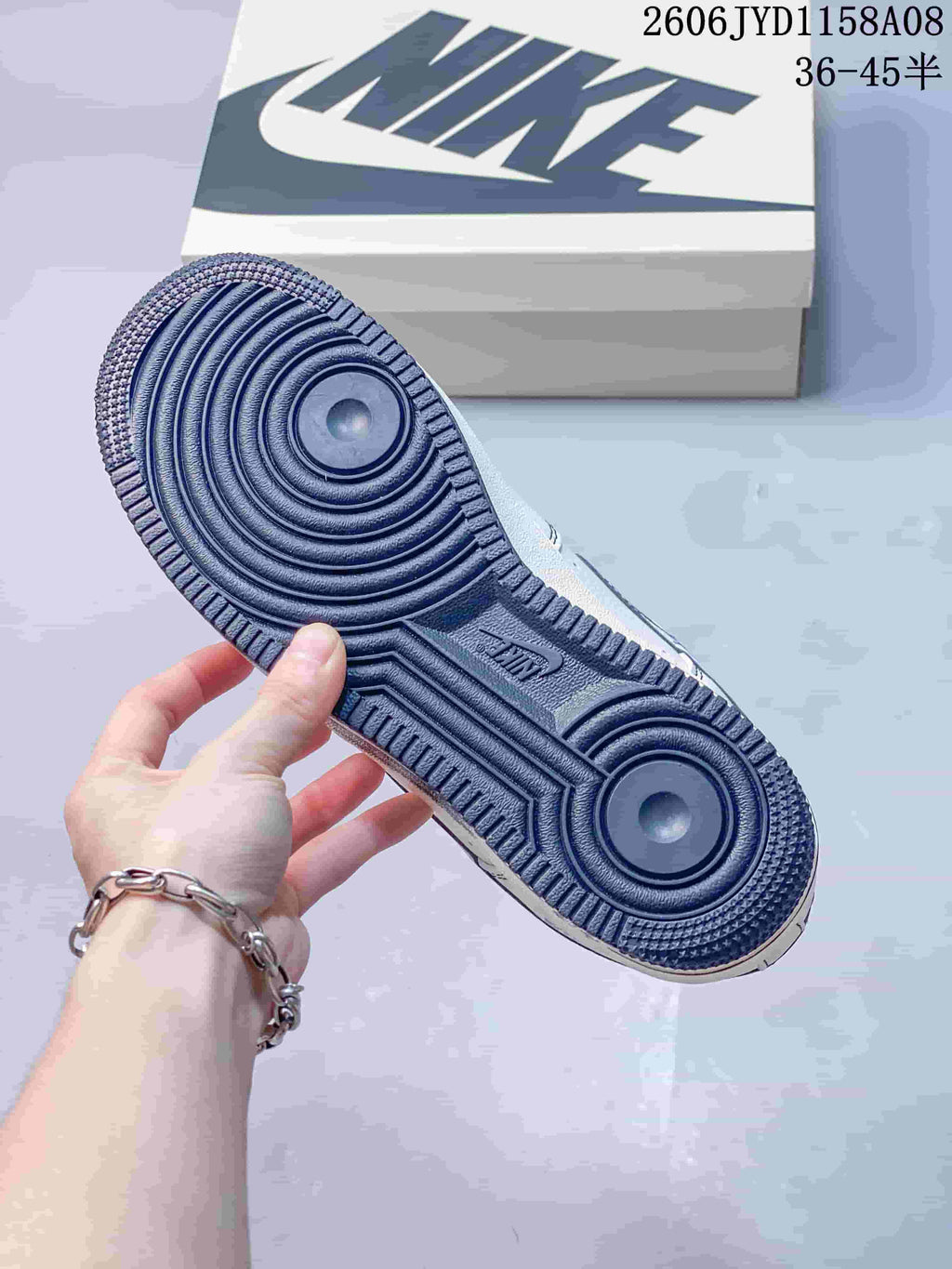 Underside of the sneaker showing its navy circular-pattern outsole.