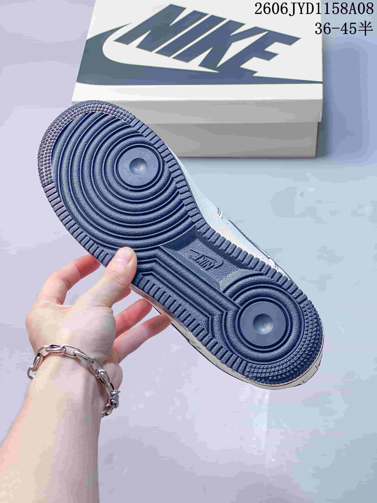 Underside of the sneaker showing its navy circular-pattern outsole.