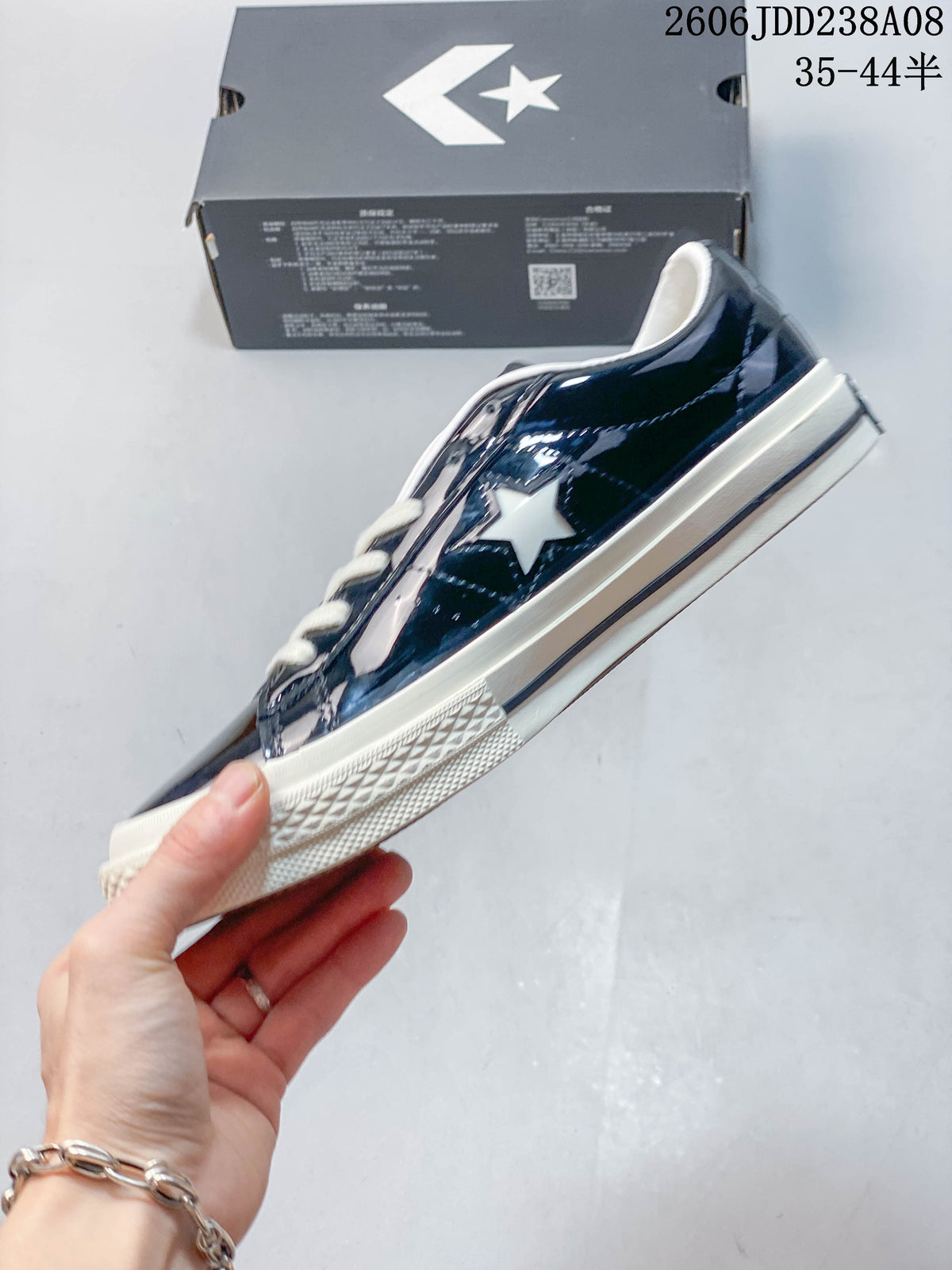 Side profile showing the glossy navy upper, white star detail, and off-white sole.