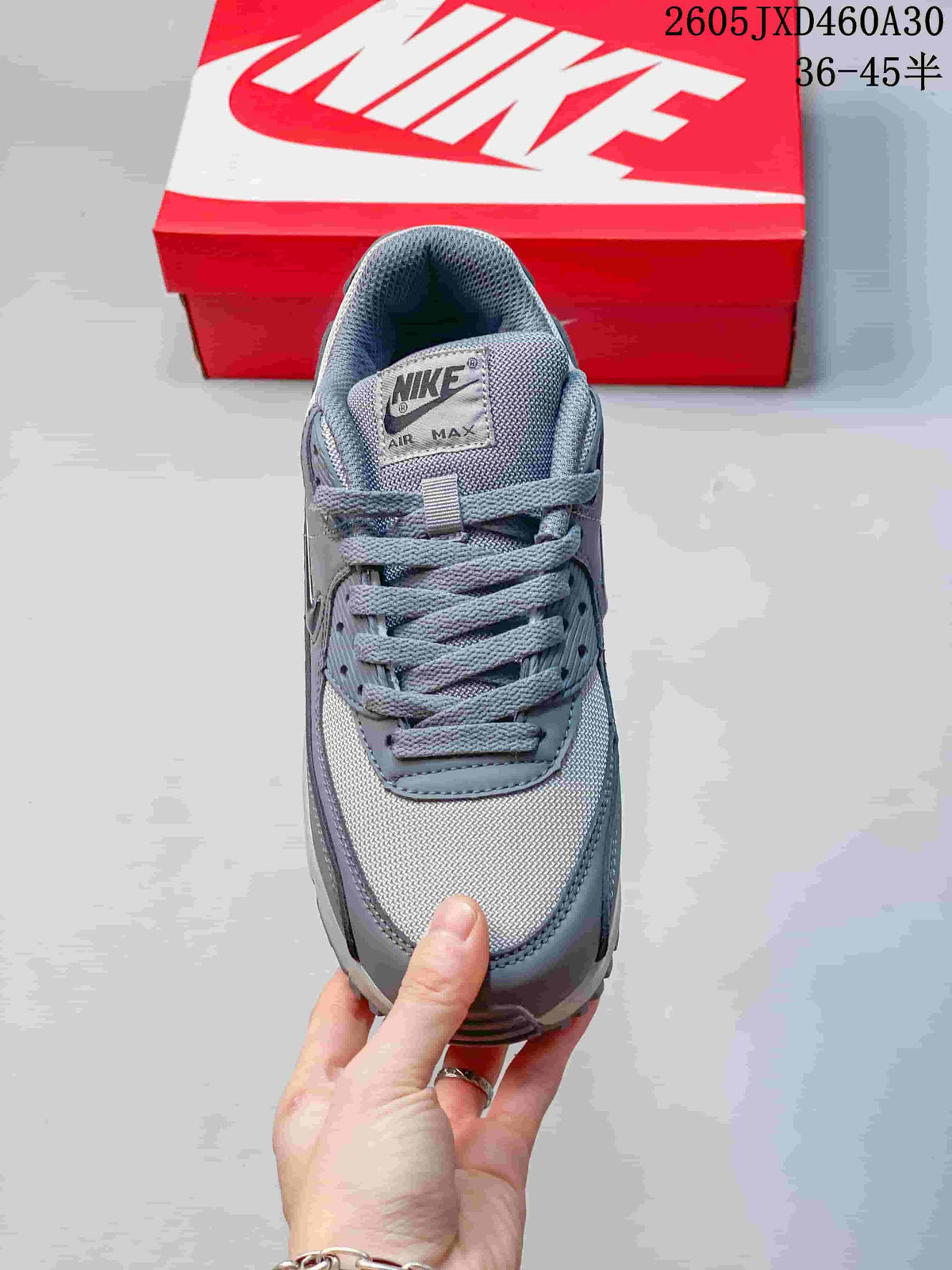 Top view of a grey Nike Air Max 90 sneaker with laces and mesh panels