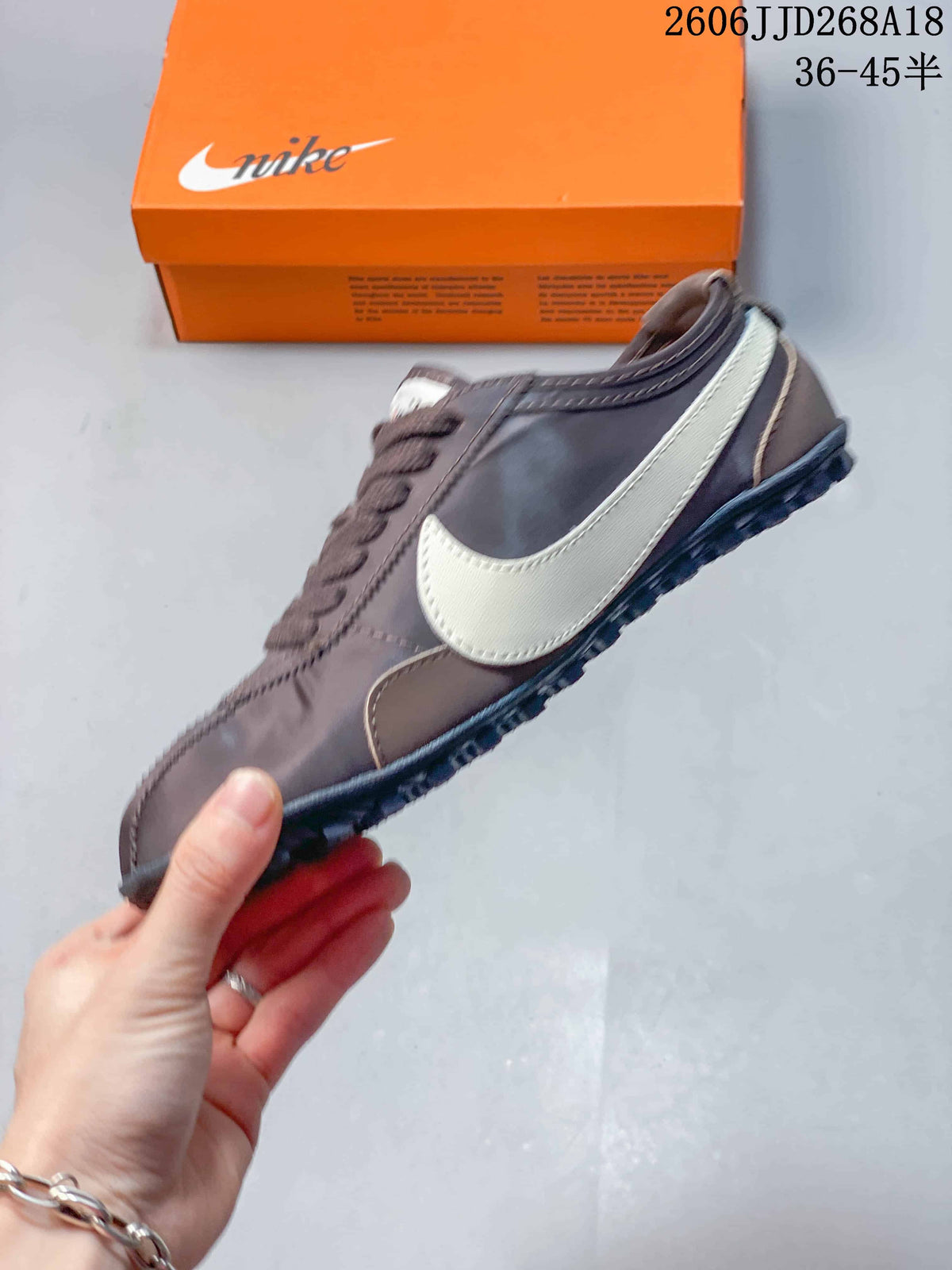 Side view of the brown sneaker with a light-colored Swoosh and lugged outsole.