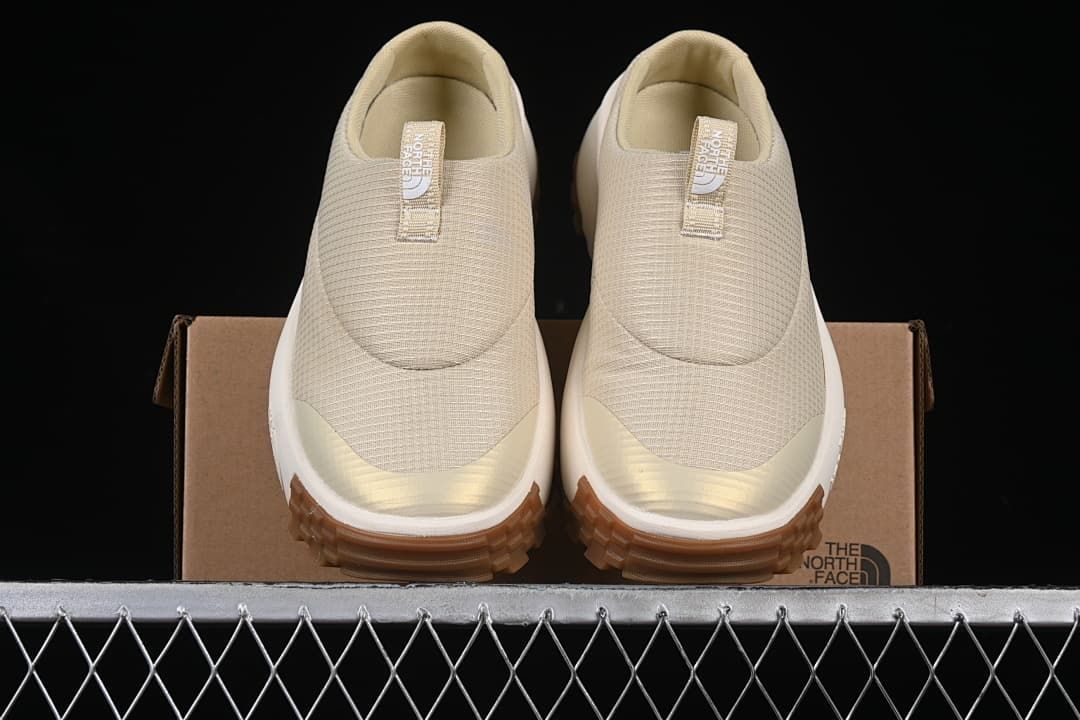 Front view of the pair of mule sneakers resting on the shoebox.