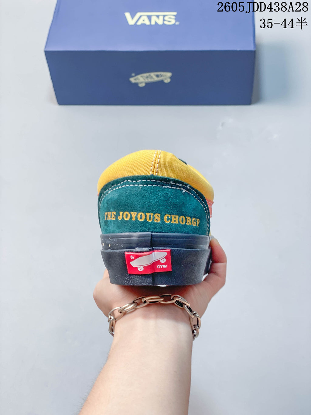 Rear view showing yellow and teal heel panels and “THE JOYOUS CHORG” lettering