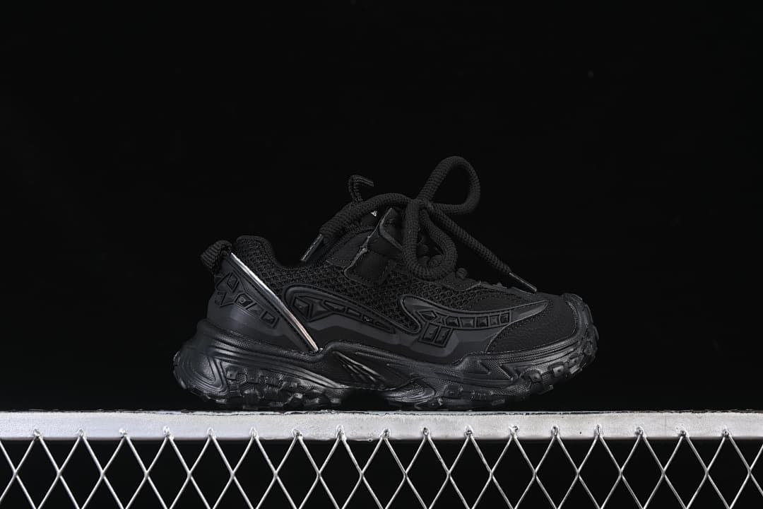 Side profile of a black children's sneaker with a chunky treaded sole.