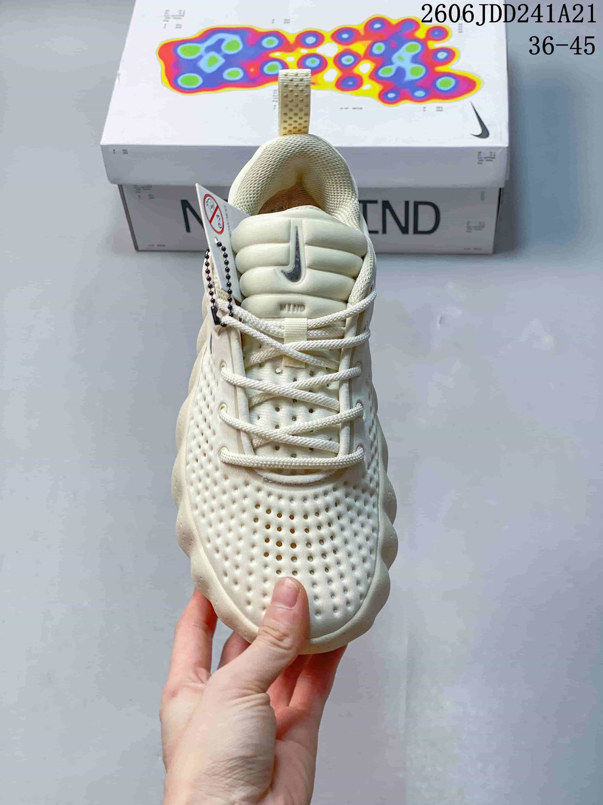 Front view of a cream Nike Mind sneaker with laces and padded tongue