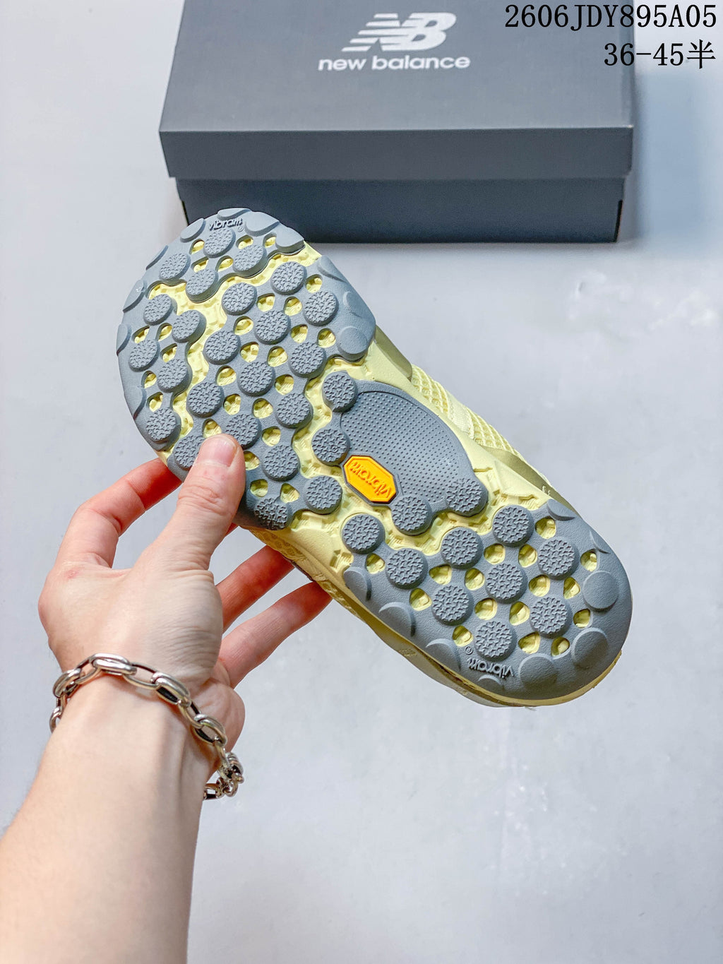 Close-up of the sneaker outsole showing gray lugged tread and a yellow Vibram-marked section