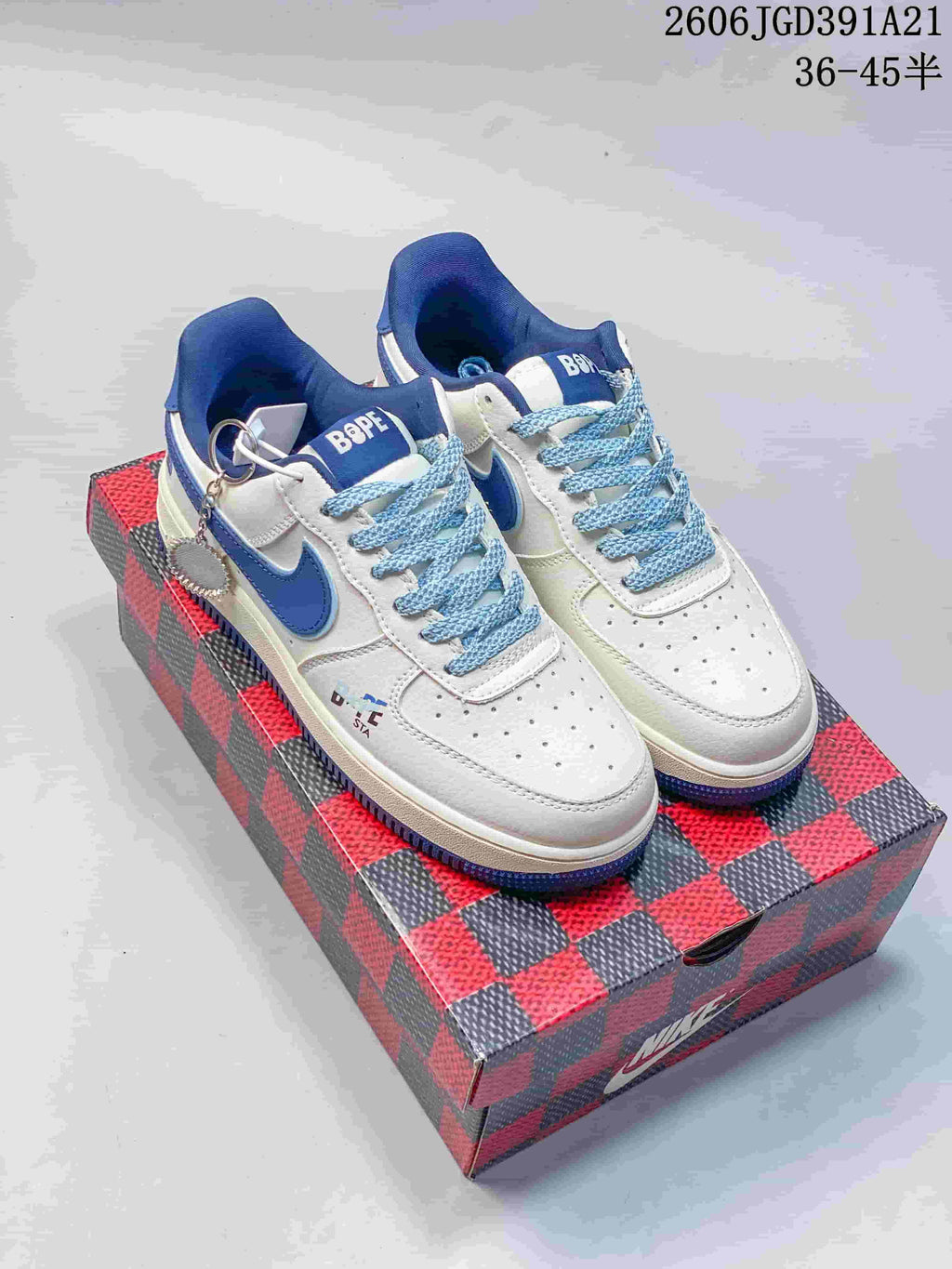 White low-top sneakers with blue accents, patterned blue laces, and decorative lace charms.