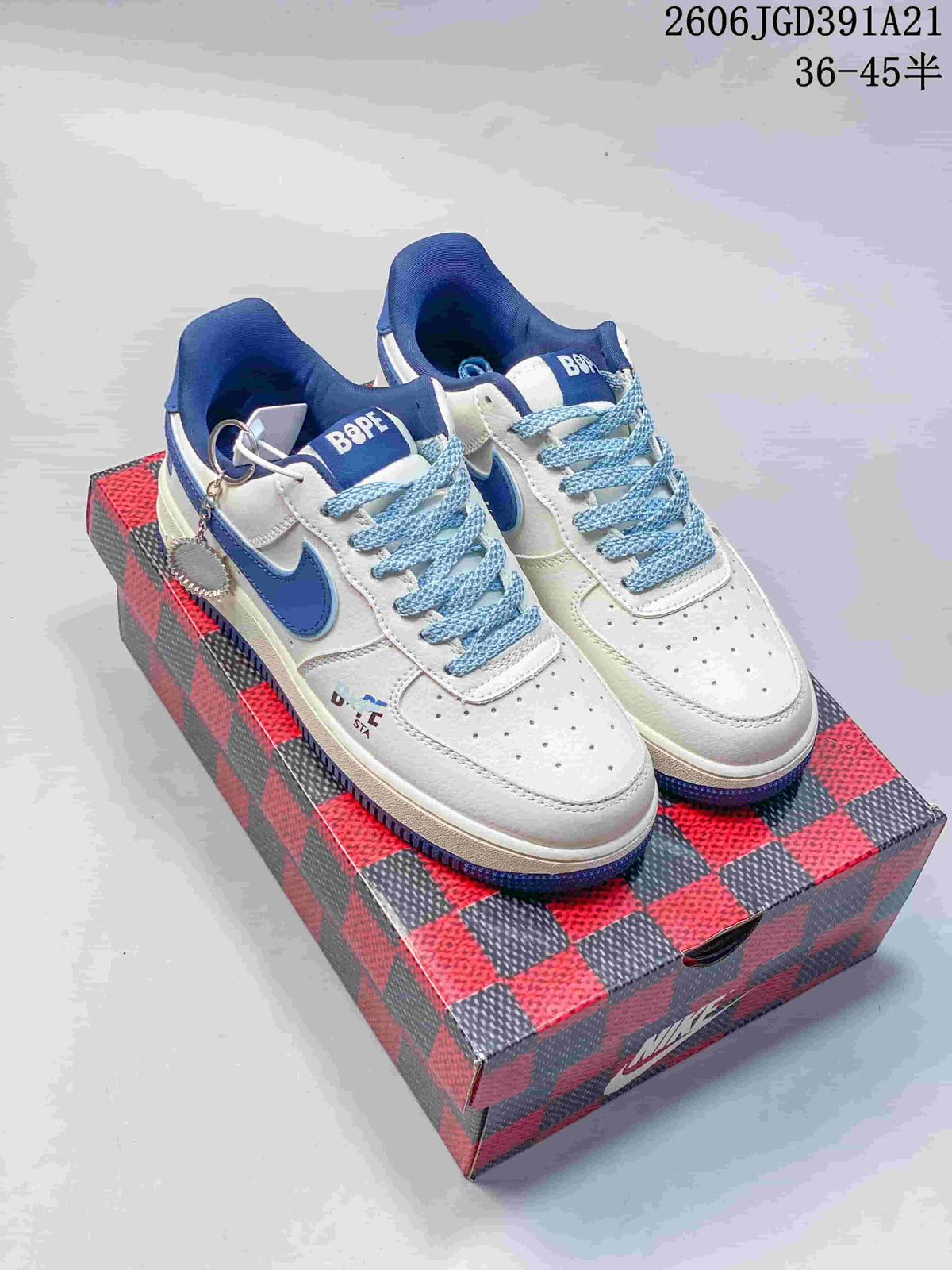 White low-top sneakers with blue accents, patterned blue laces, and decorative lace charms.