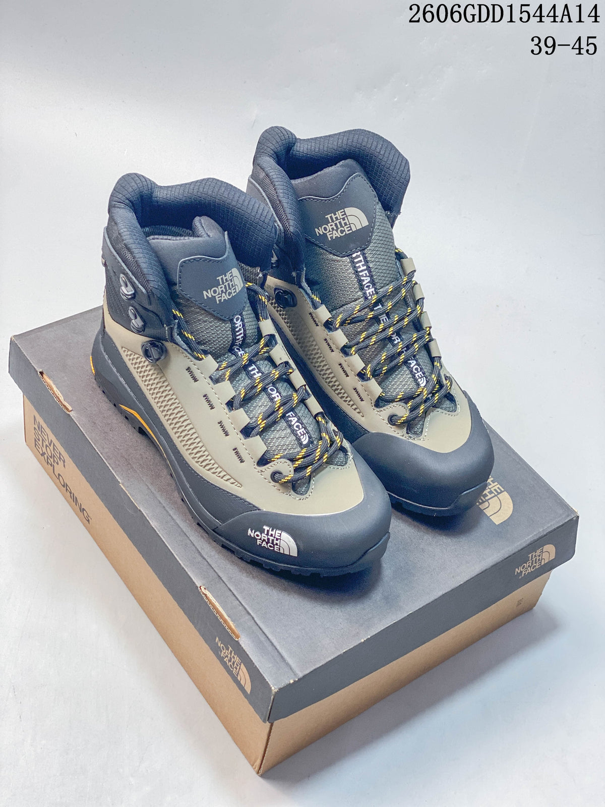 Pair of gray, khaki, and navy The North Face Verto Alpine high-top hiking boots on a branded box.