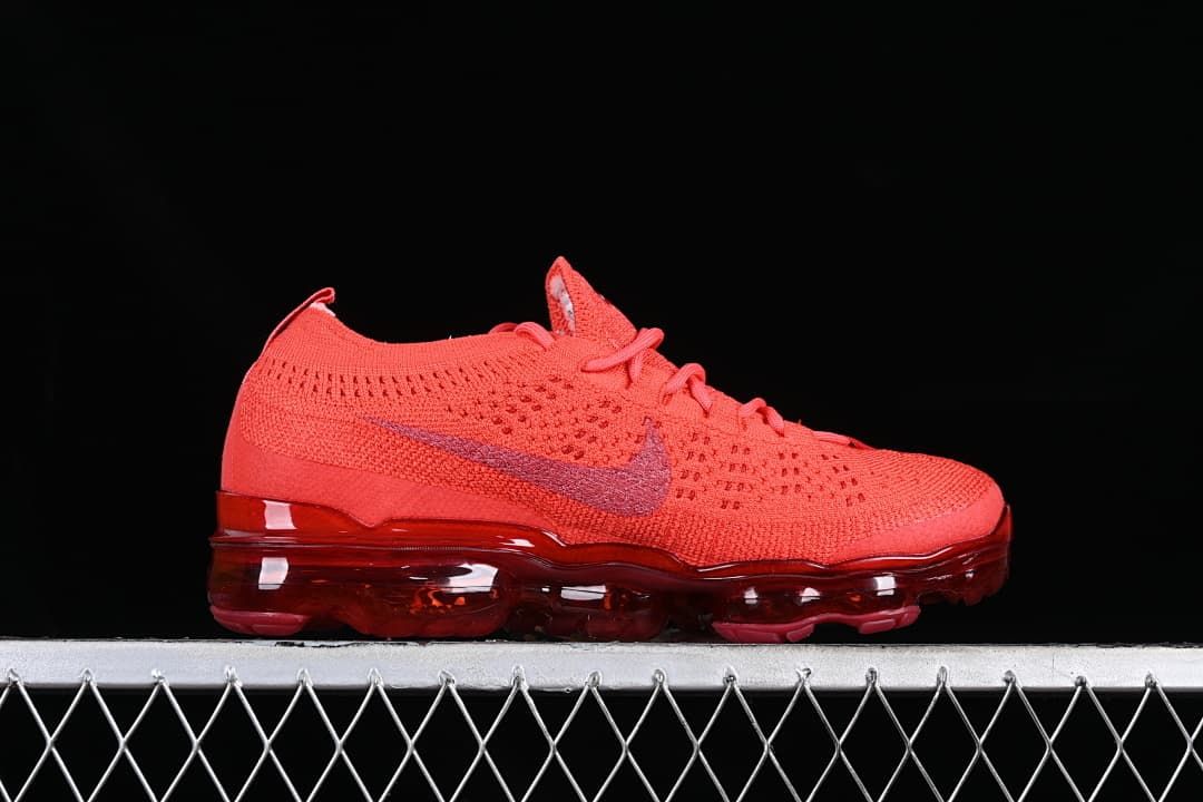 Side profile of the red knit sneaker with Swoosh and full-length sole